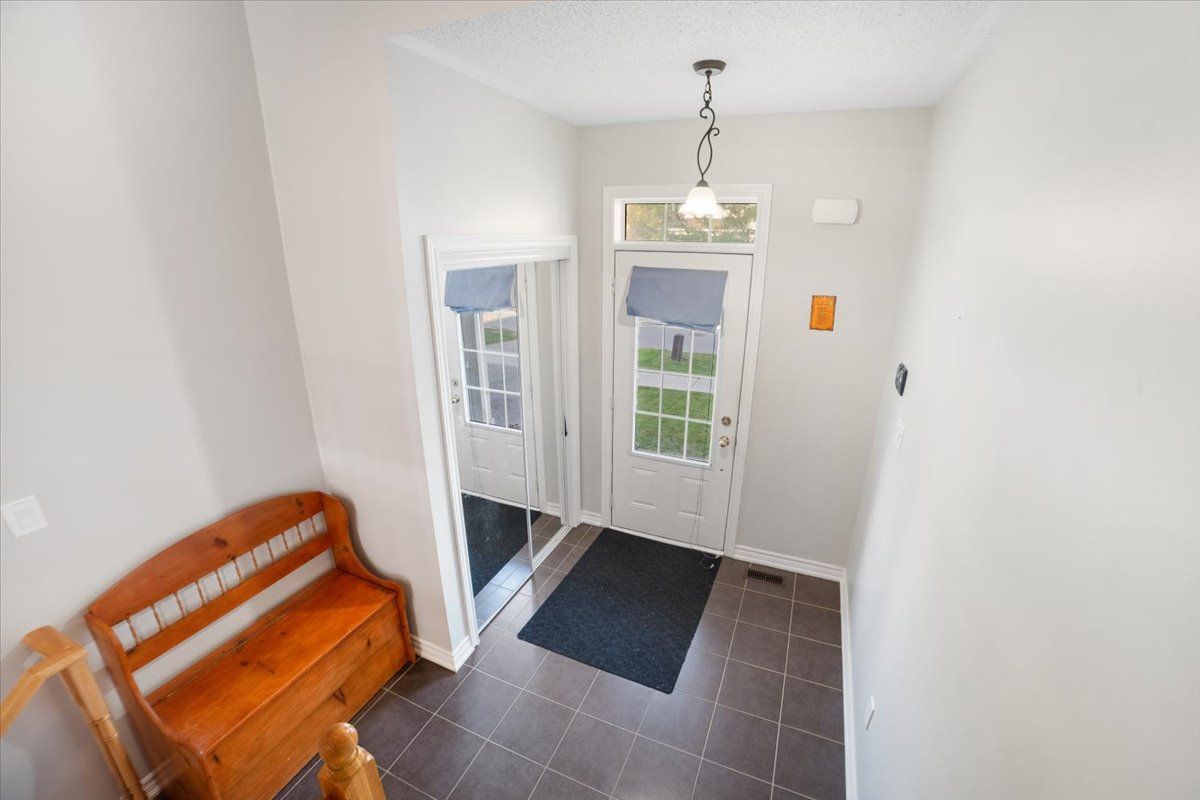 A hallway with a bench and a mirror in a house.