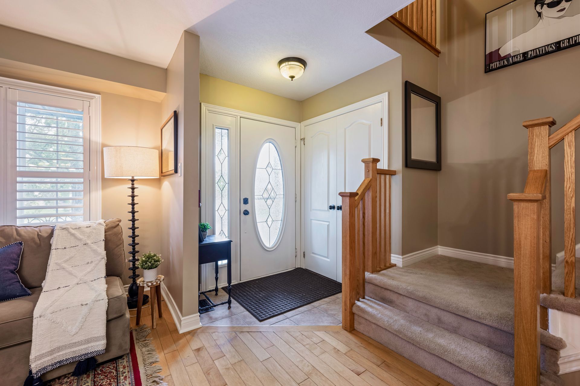 A living room with a couch and stairs leading up to the second floor.