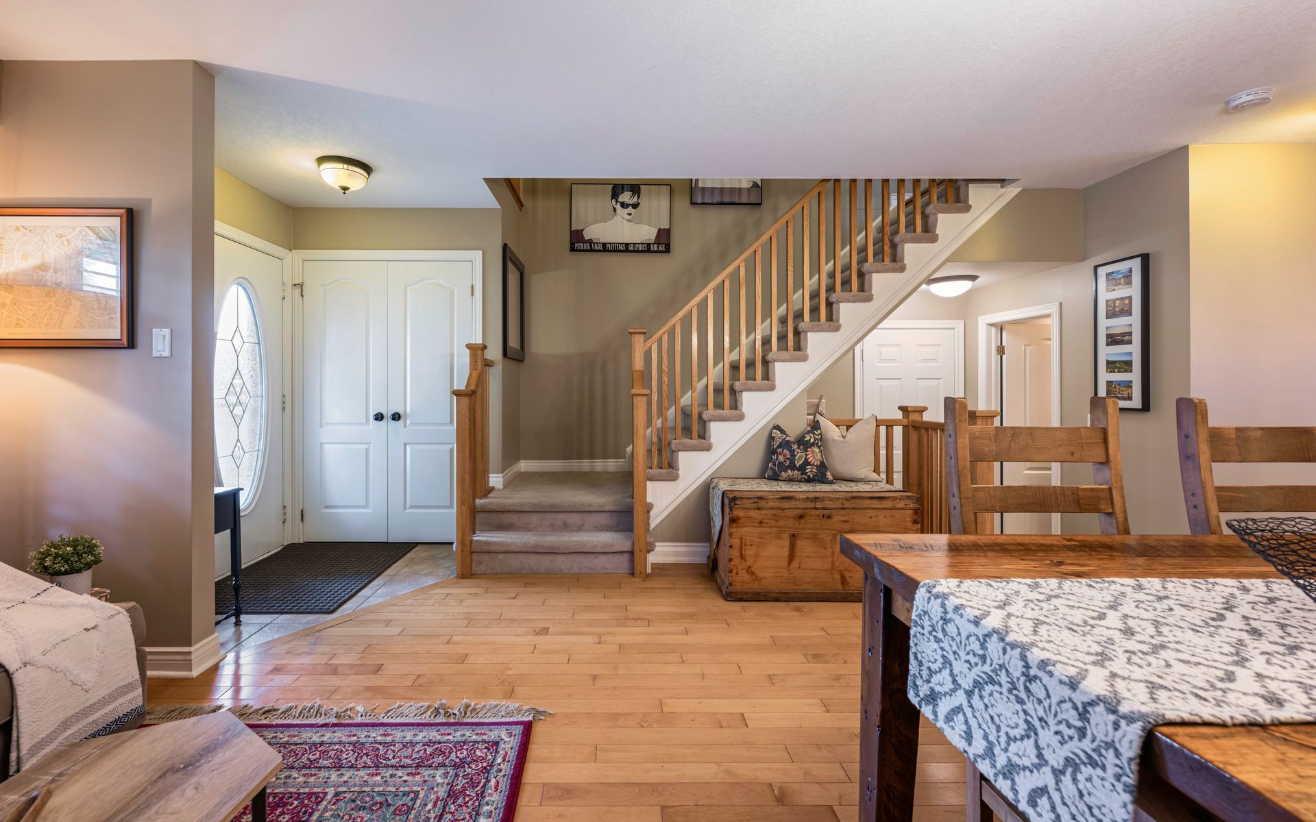 A living room with hardwood floors and stairs leading up to the second floor.