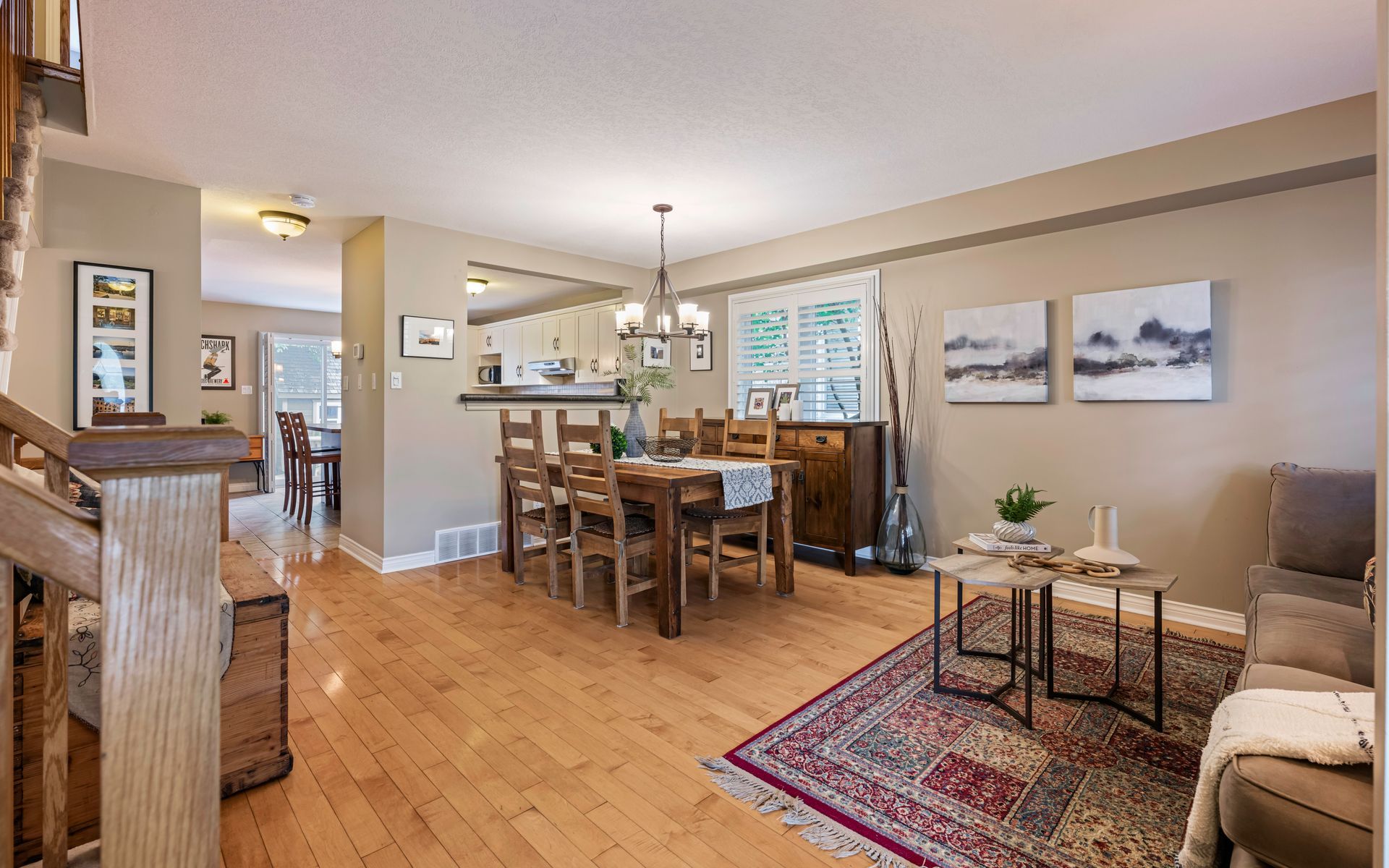 A living room with hardwood floors and a dining room with a table and chairs.