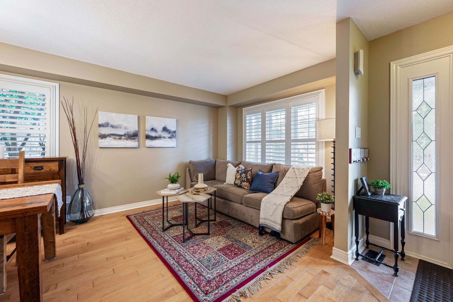 A living room with a couch , rug , table and chairs.