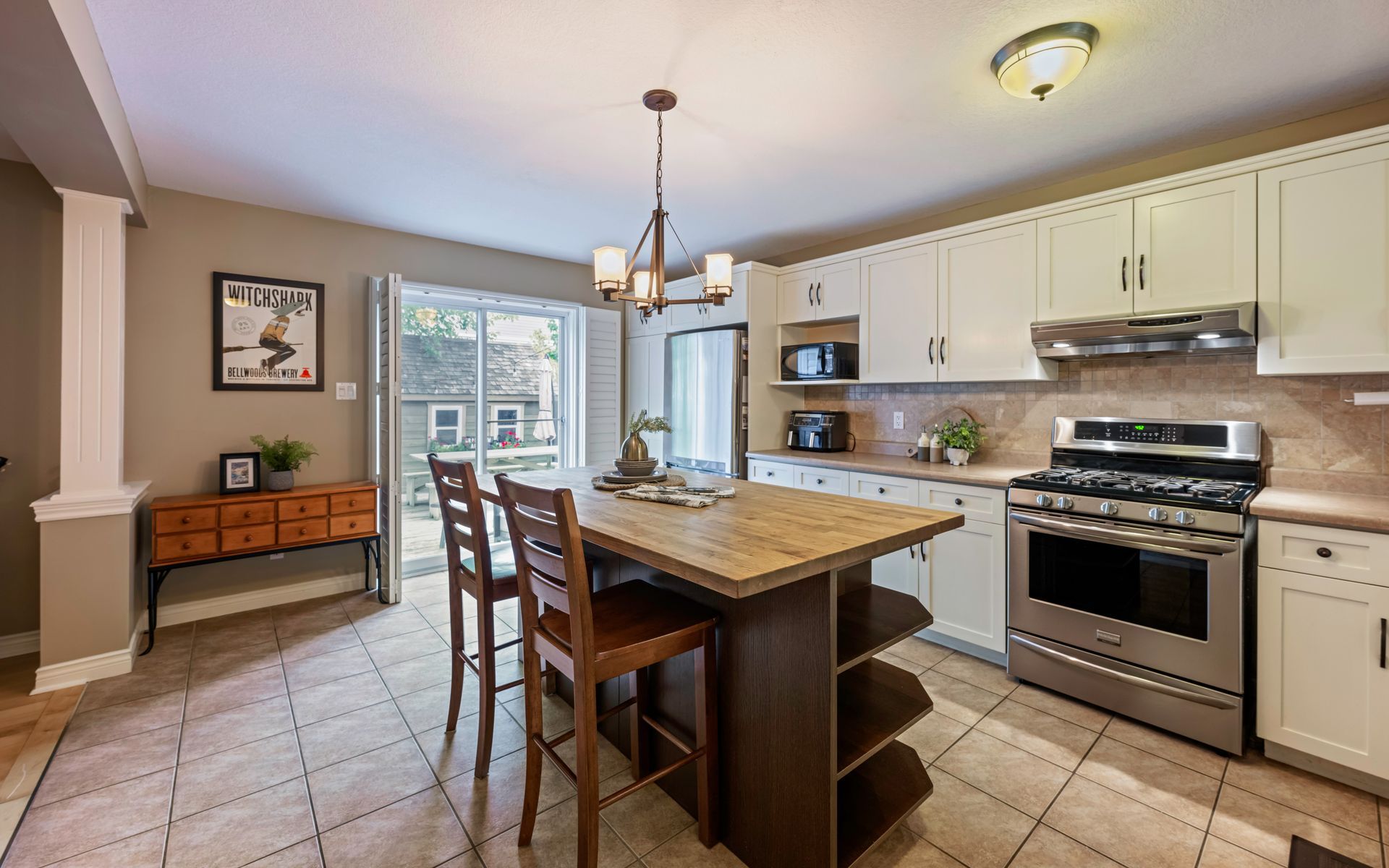 A kitchen with white cabinets , stainless steel appliances and a large island.