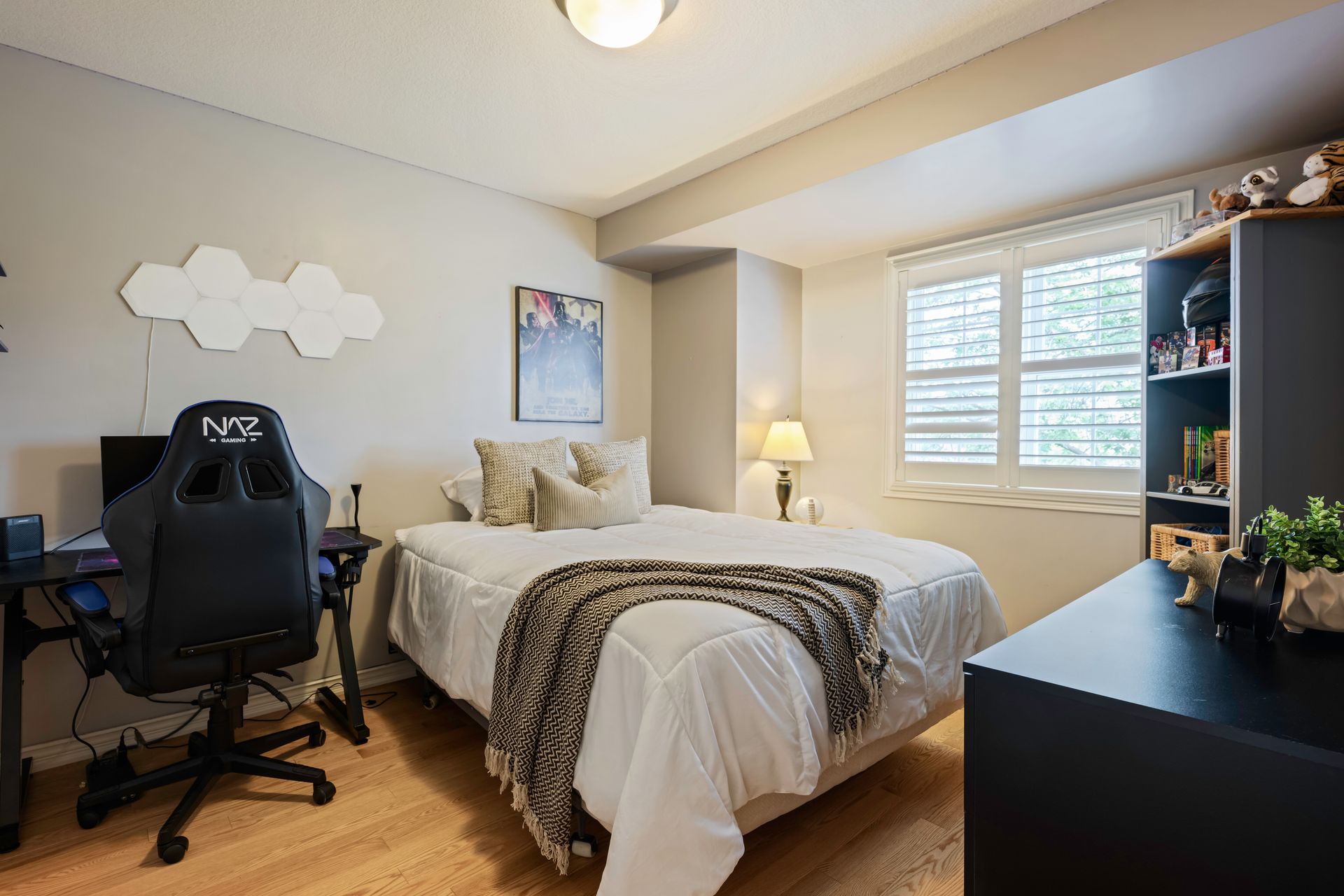 A bedroom with a bed , desk , chair and computer.