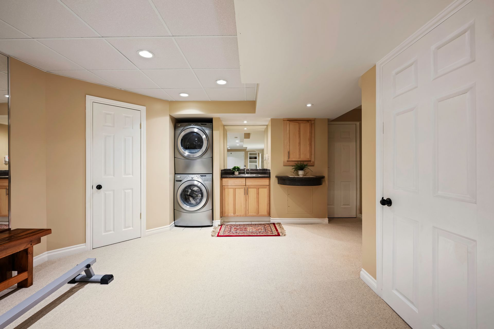 A basement with a washer and dryer stacked on top of each other.