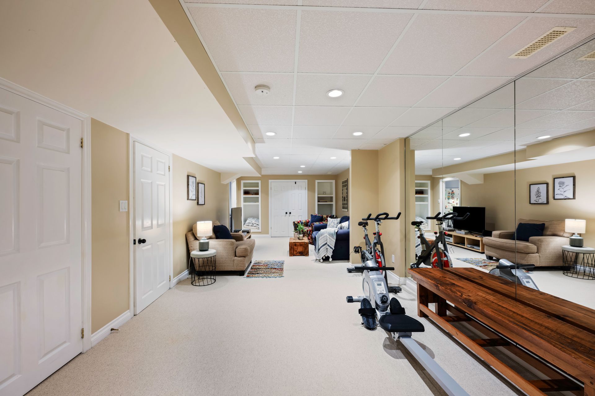 A basement with a lot of mirrors and exercise equipment