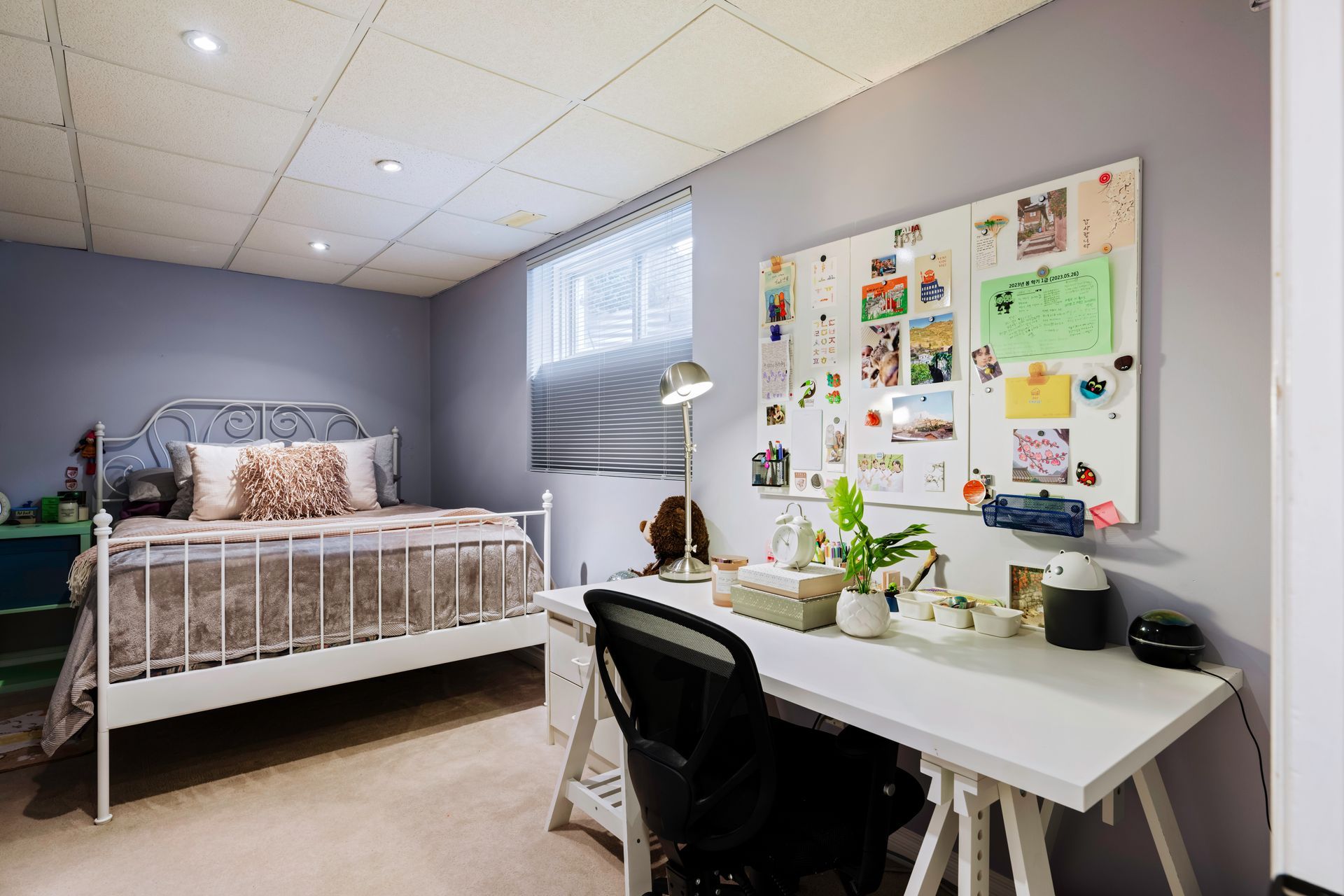 A bedroom with a bed , desk and chair.