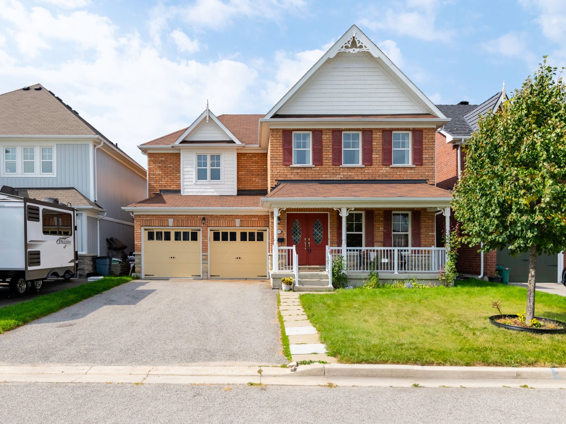 A large brick house with a rv parked in front of it.