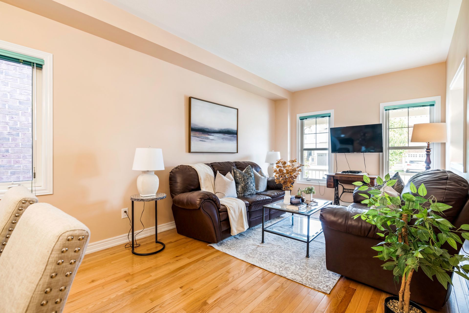 A living room with a couch , chair , coffee table and television.