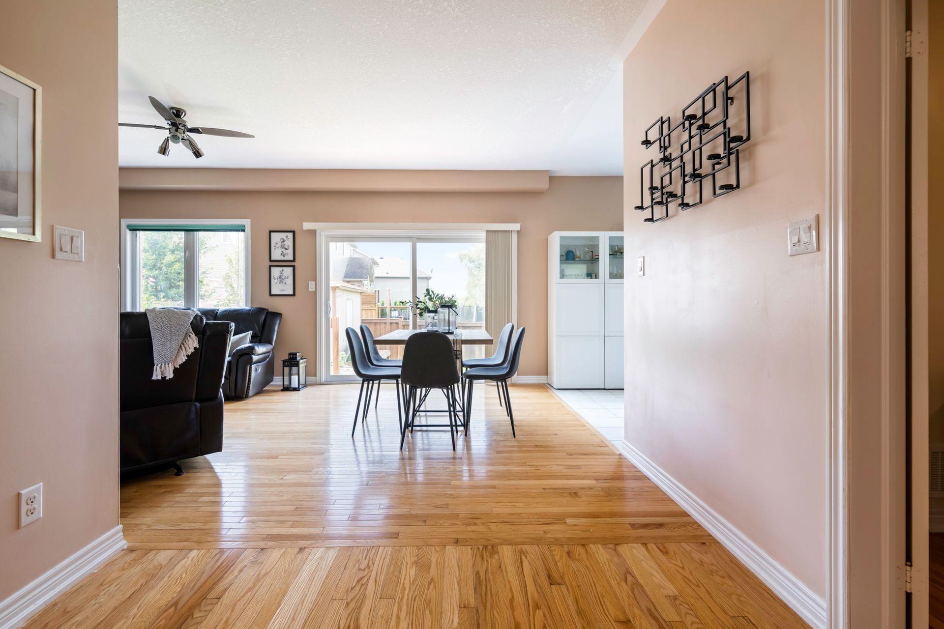 A living room with hardwood floors and a ceiling fan