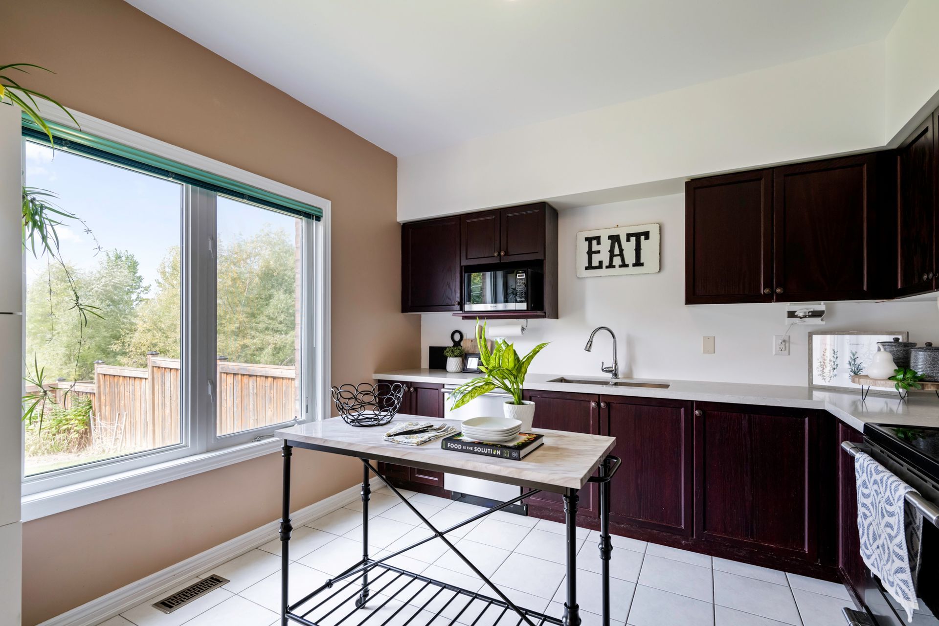 A kitchen with a table and a sign that says eat on the wall.