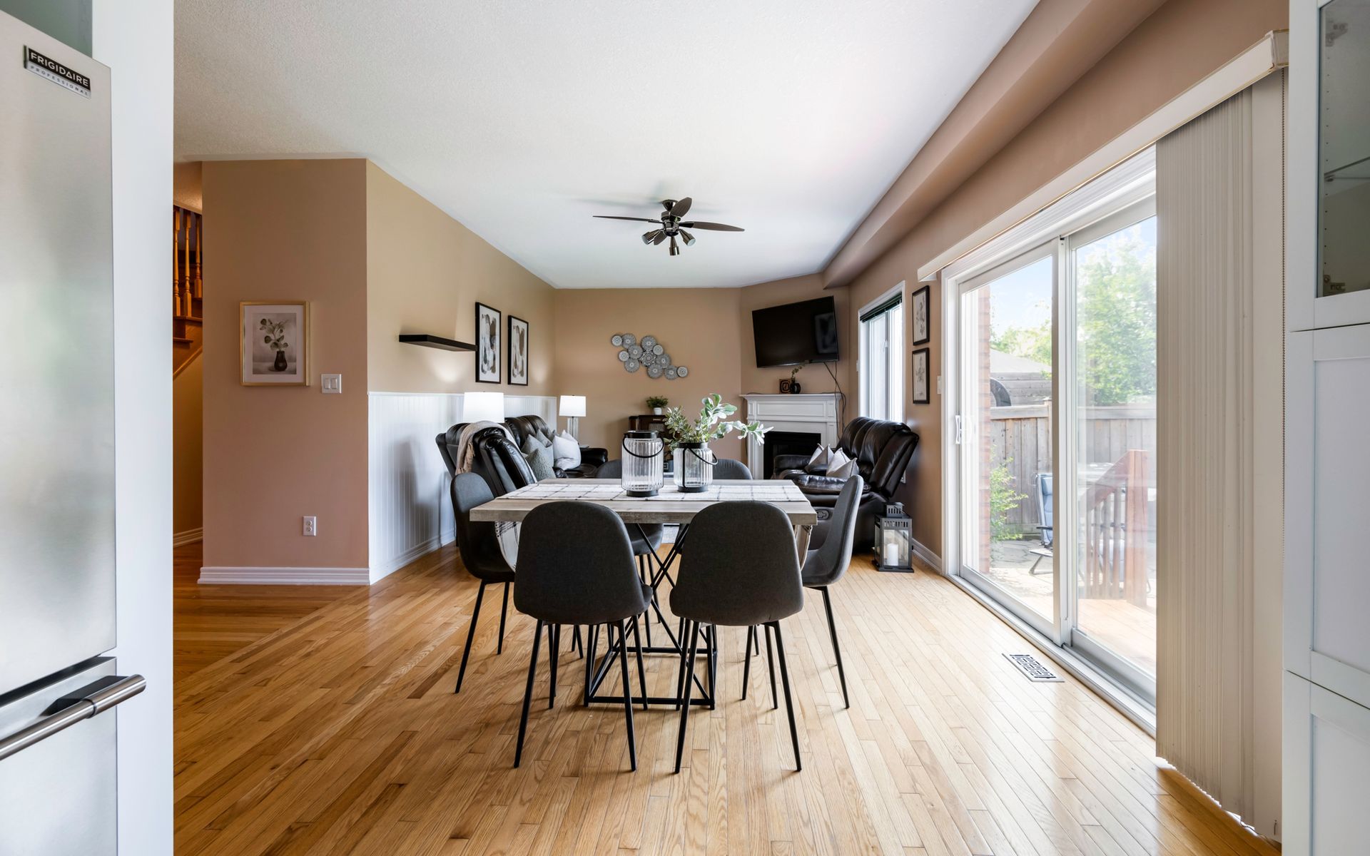 A dining room with a table and chairs and sliding glass doors