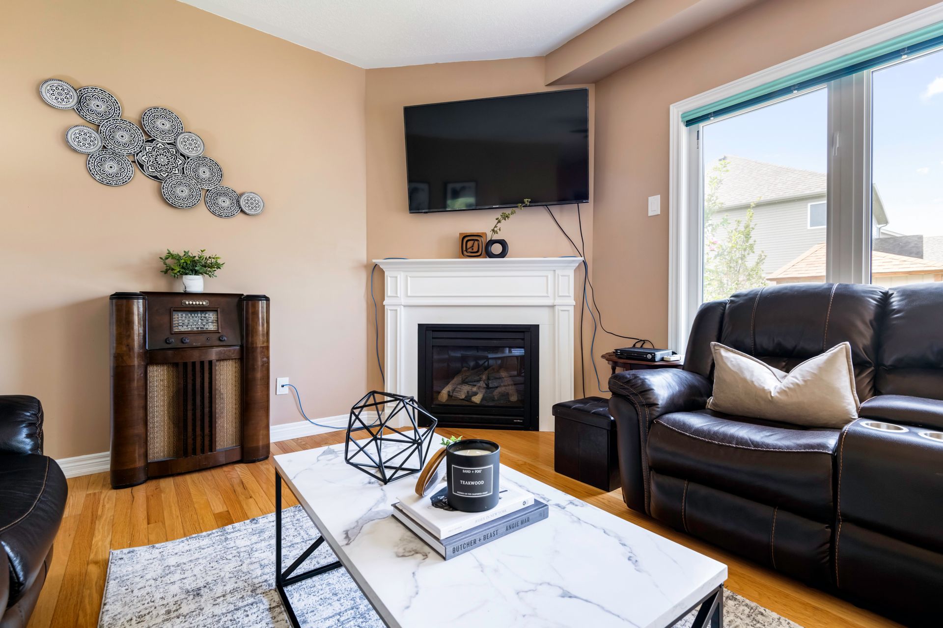 A living room with a couch , coffee table , fireplace and television.