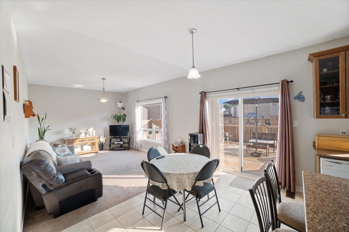A living room with a table and chairs and a sliding glass door.
