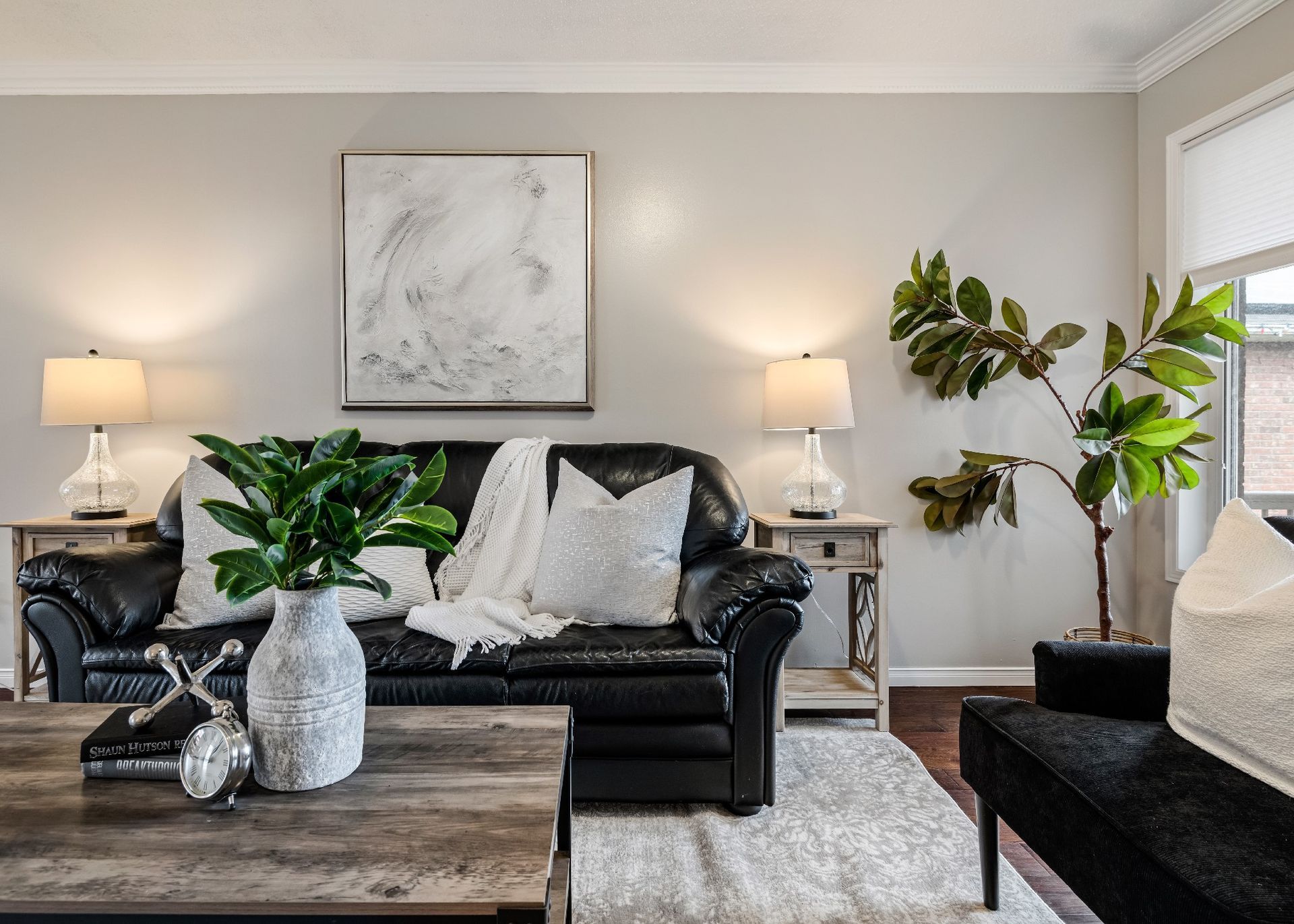A living room with a black couch and a coffee table.
