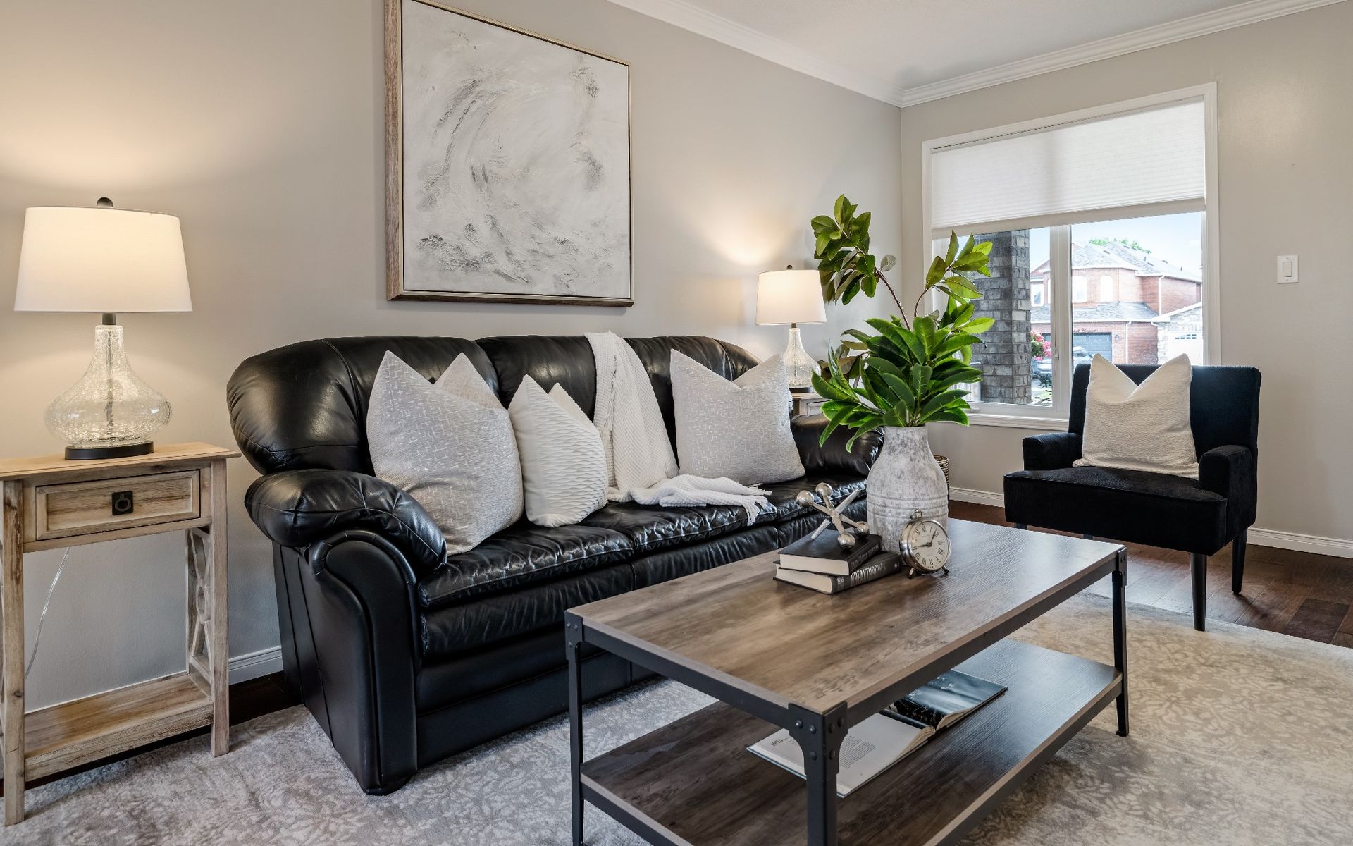 A living room with a black couch and a wooden coffee table.