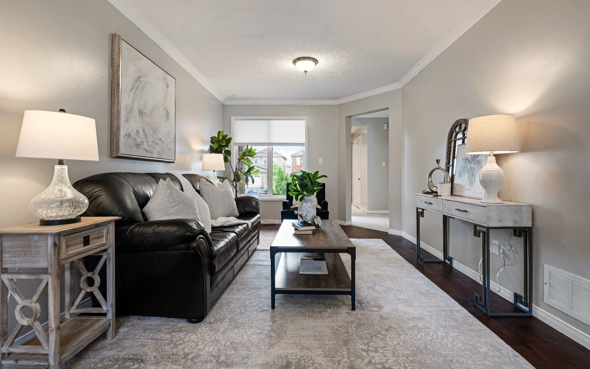 A living room with a couch , coffee table , lamps and a rug.