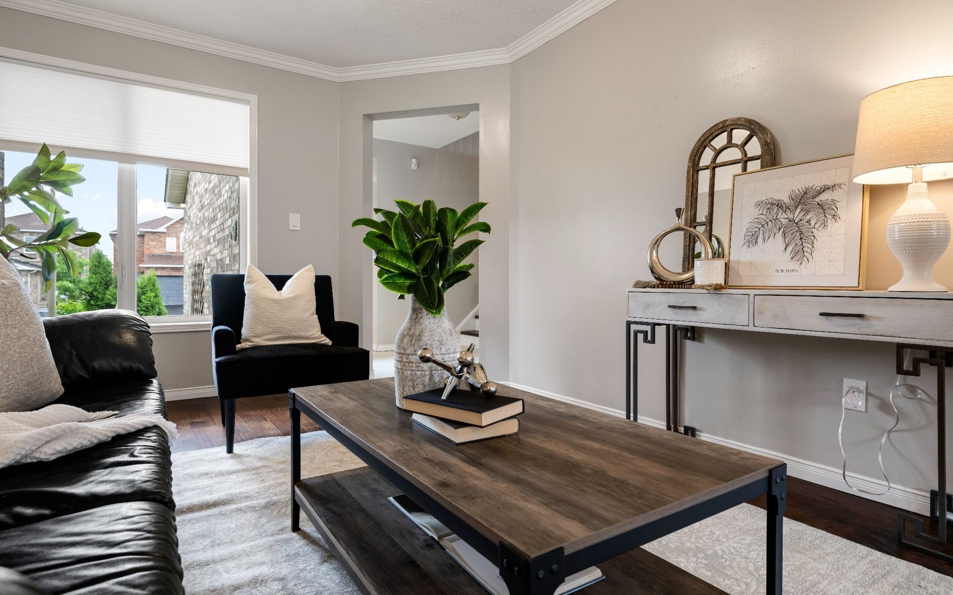 A living room with a couch , chair , coffee table and lamps.