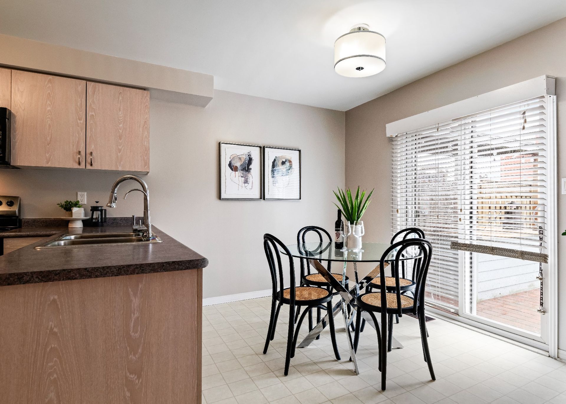 A dining room with a table and chairs next to a kitchen.