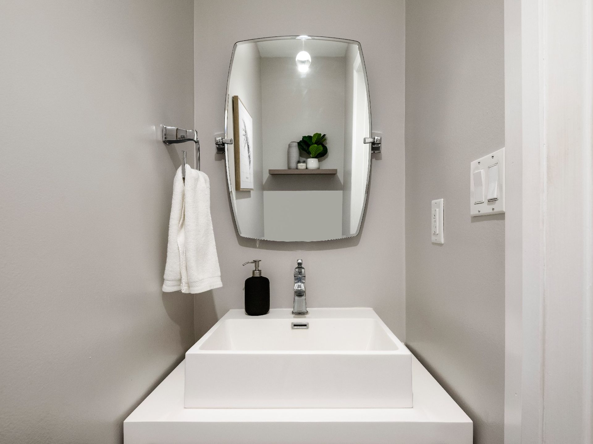 A bathroom with a sink , mirror and towel rack.