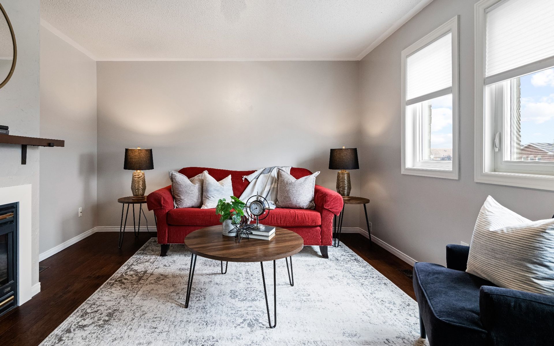A living room with a red couch , a coffee table , and a fireplace.