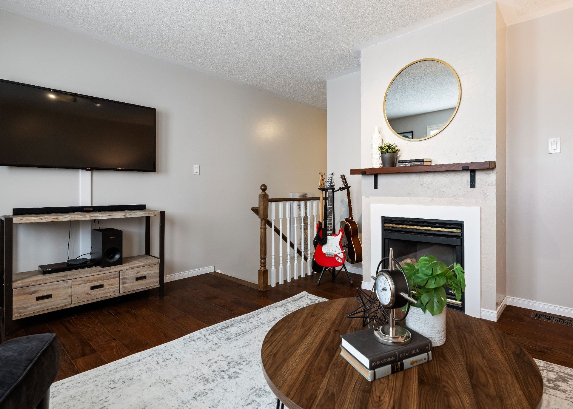 A living room with a fireplace and a flat screen tv.