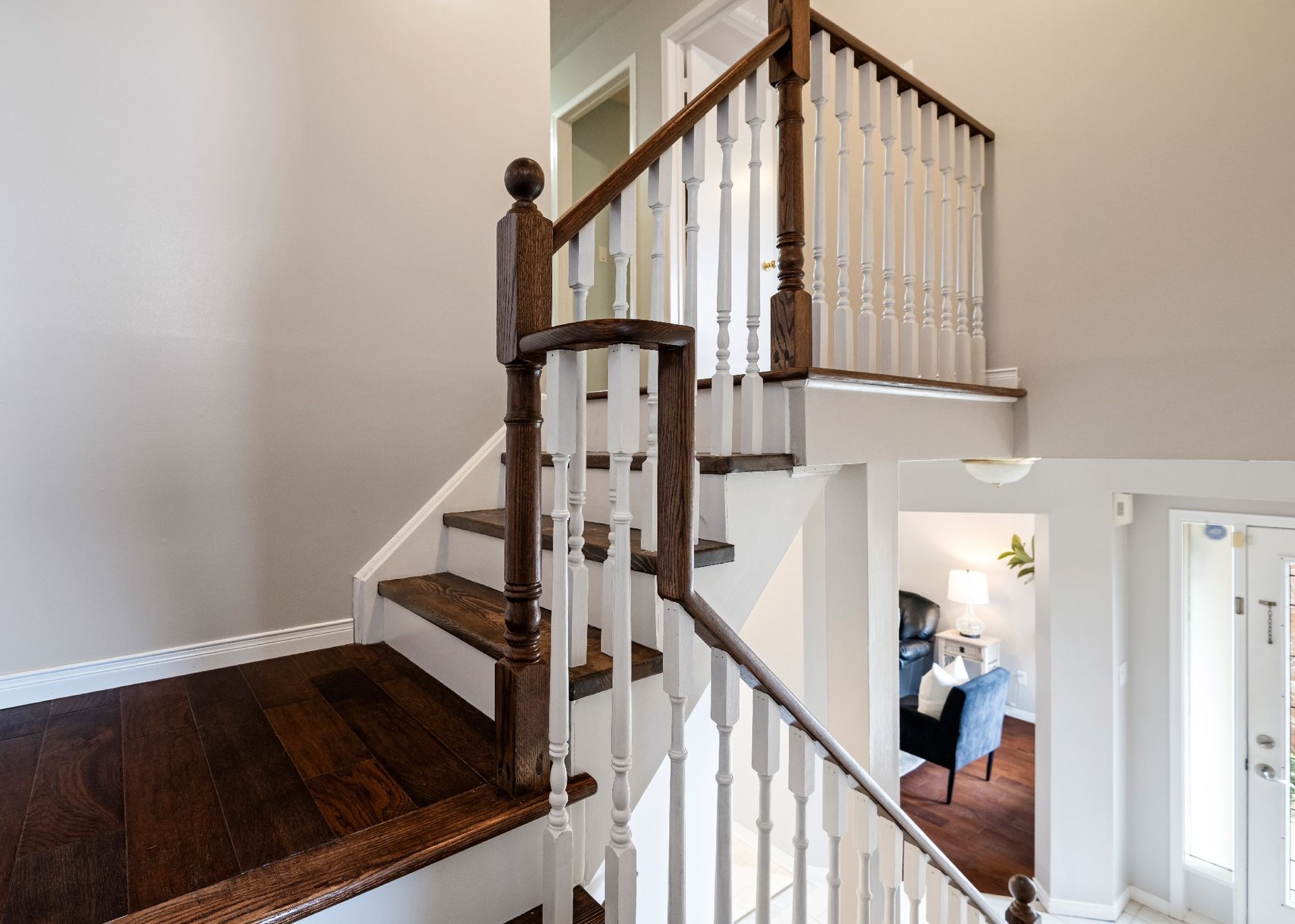 A staircase with wooden steps and a white railing in a house.