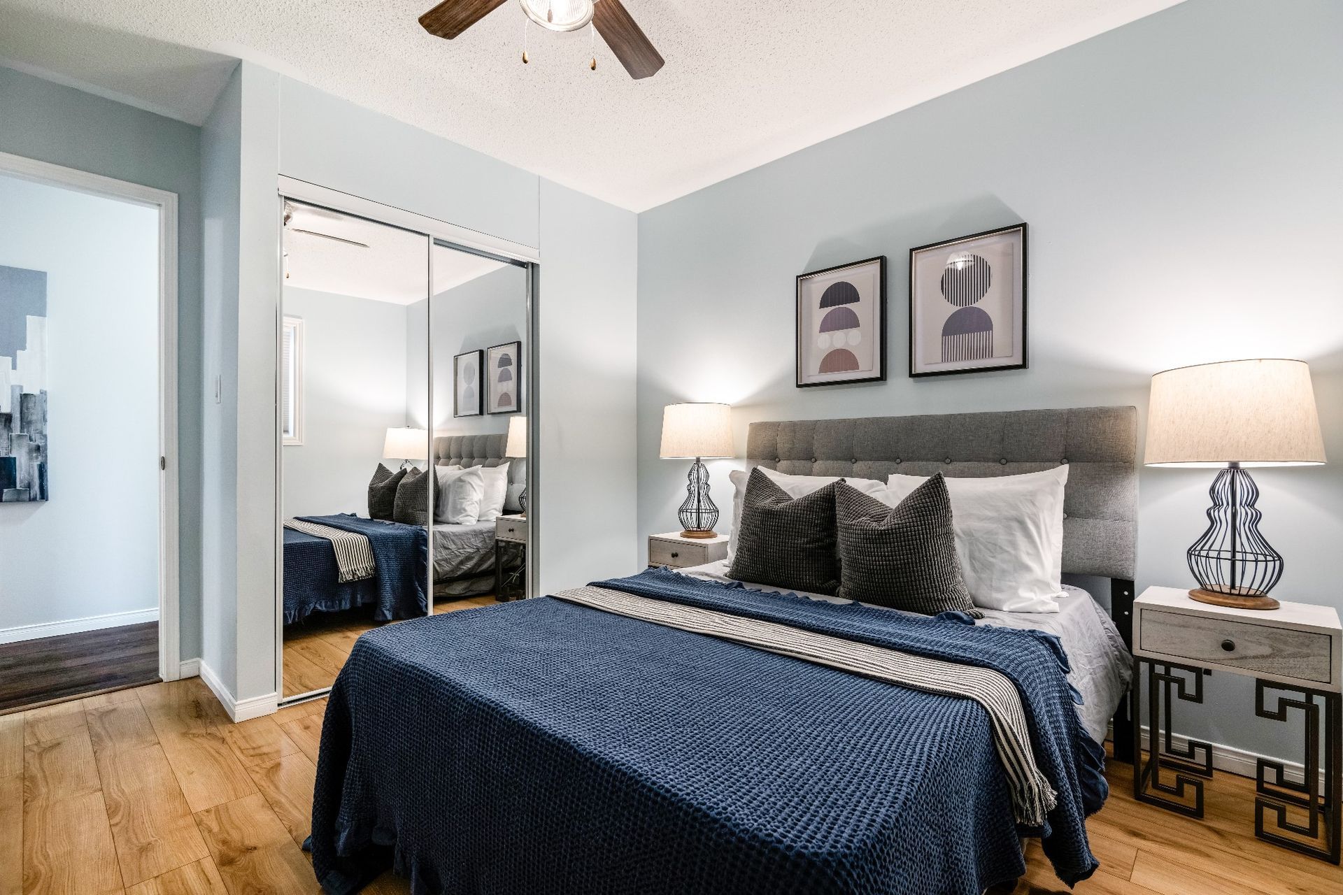 A bedroom with a large bed and a ceiling fan.