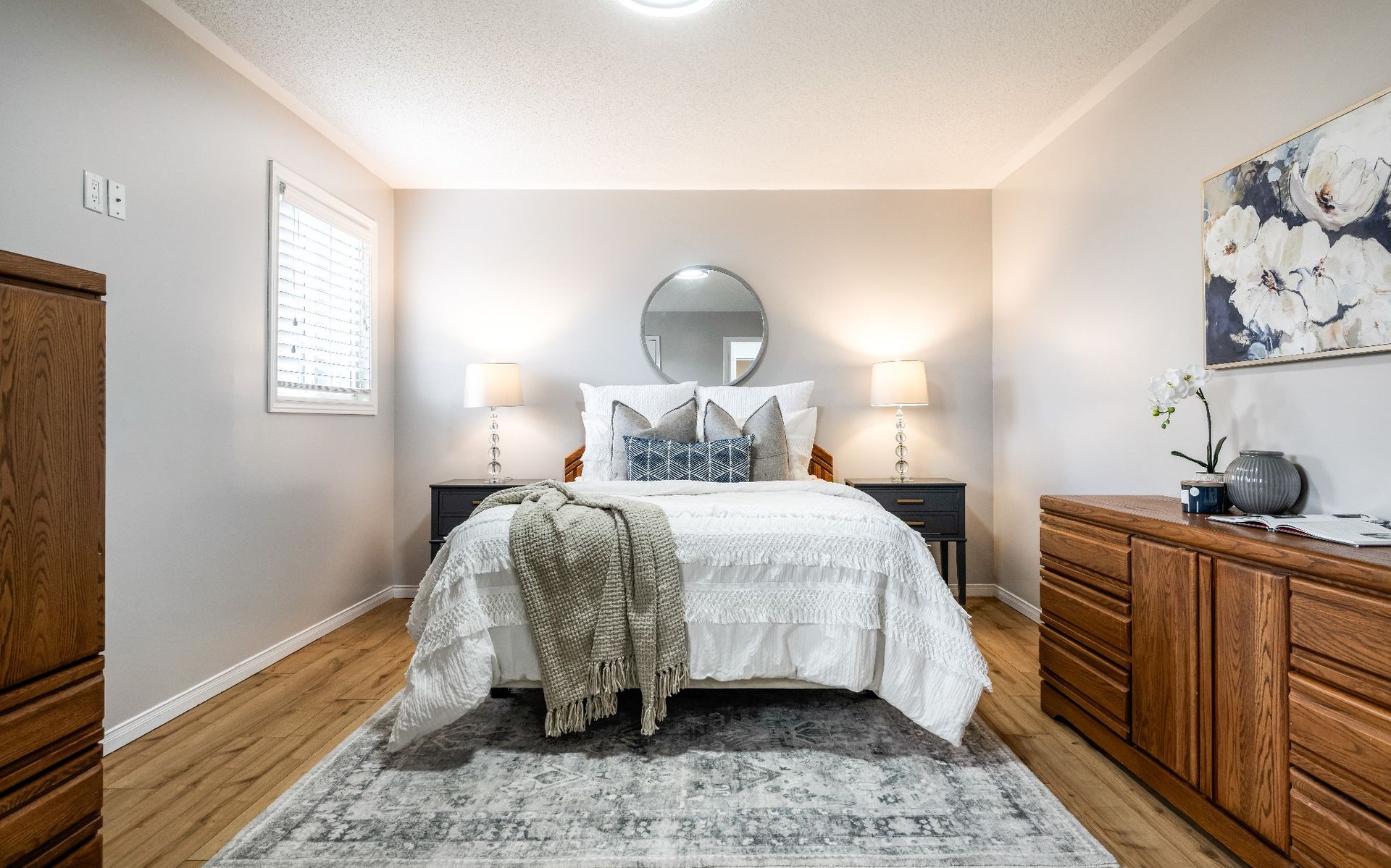 A bedroom with a bed , dresser , and rug.