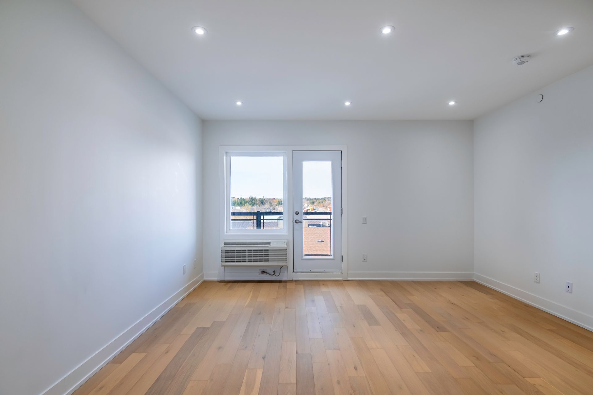 an empty room with hardwood floors and white walls