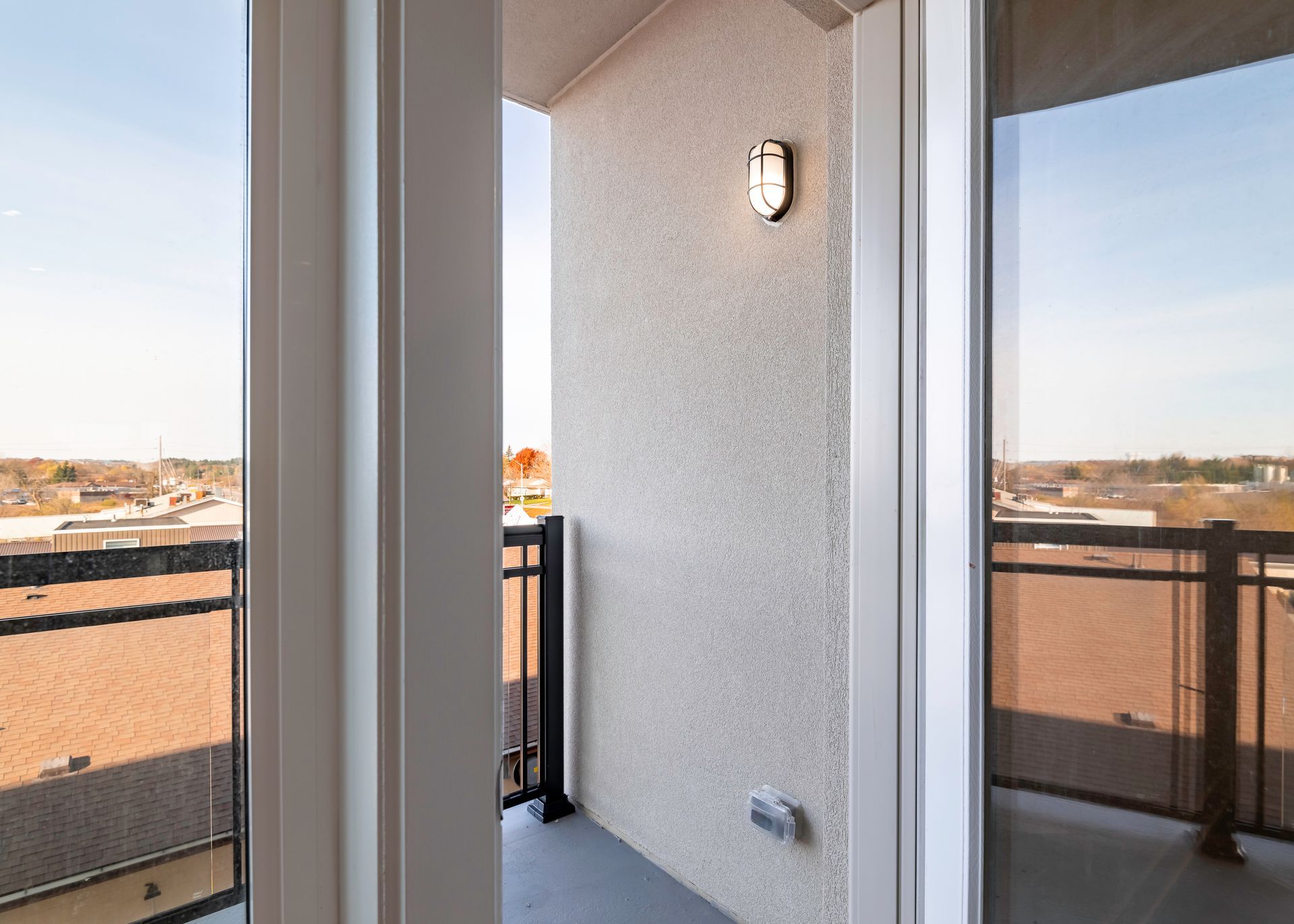 A balcony with a view of a city from a window.