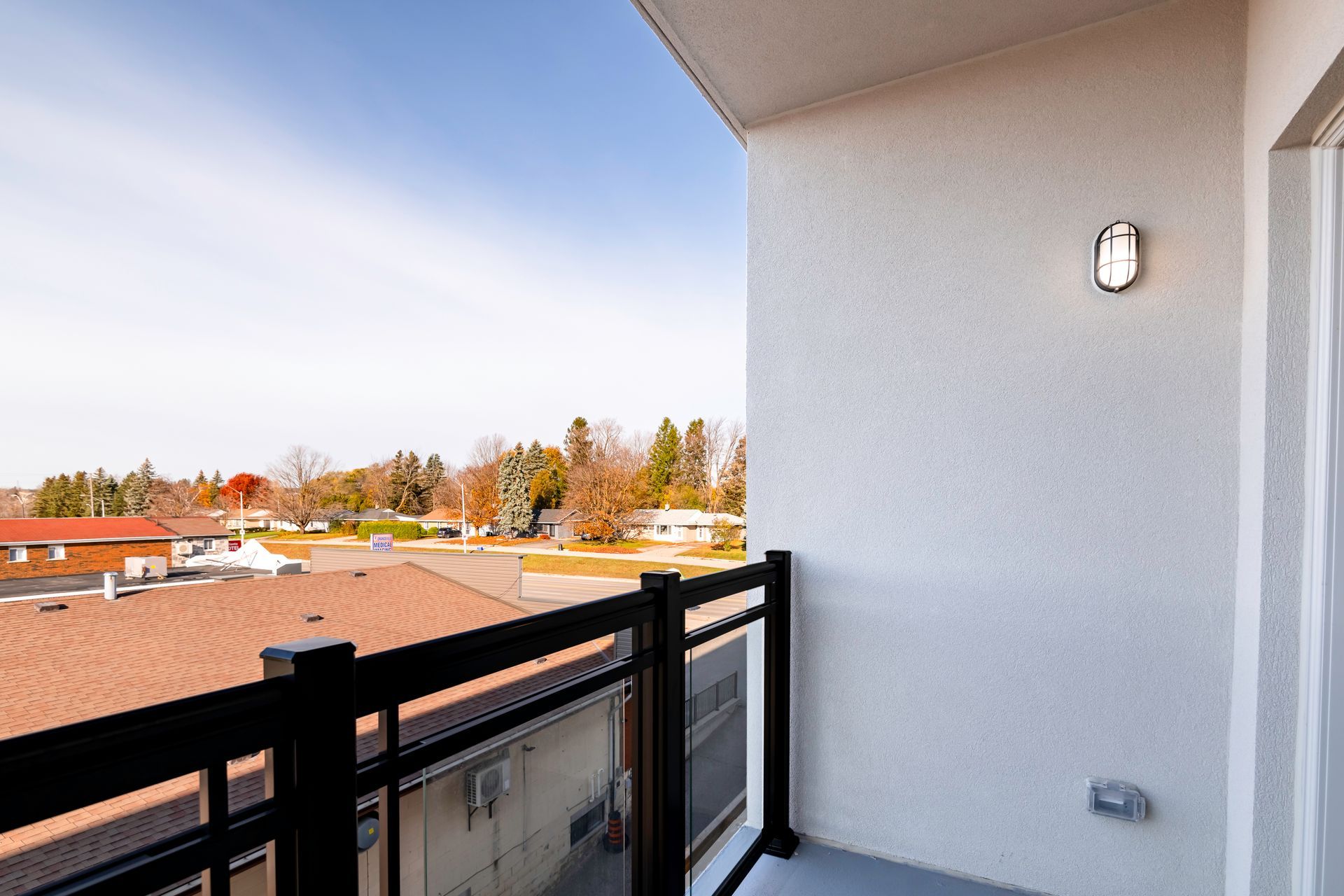 A balcony with a black railing and a view of a city.