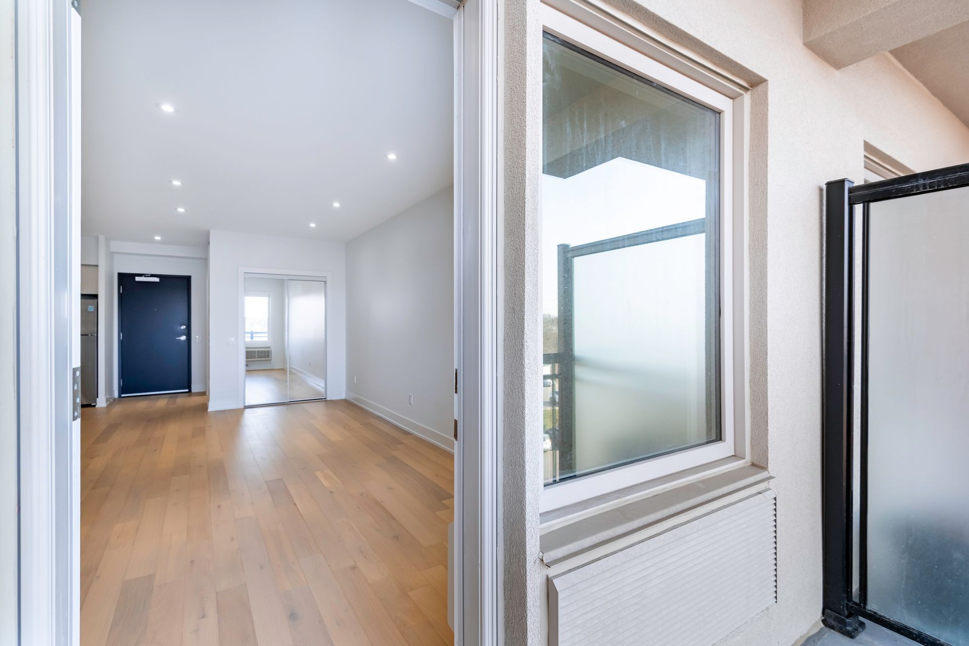 An empty room with hardwood floors and a window.