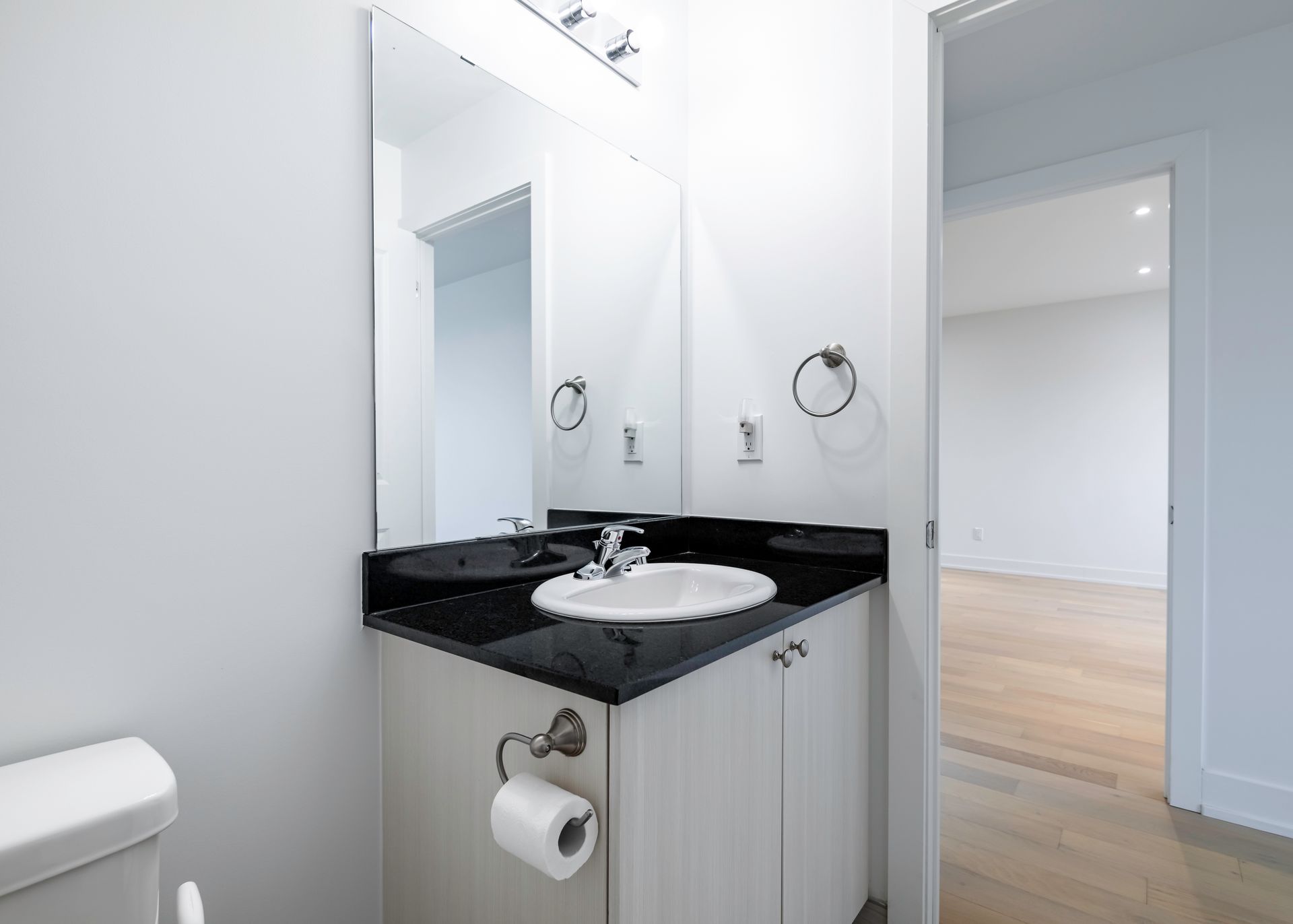 A bathroom with a sink , toilet and mirror.