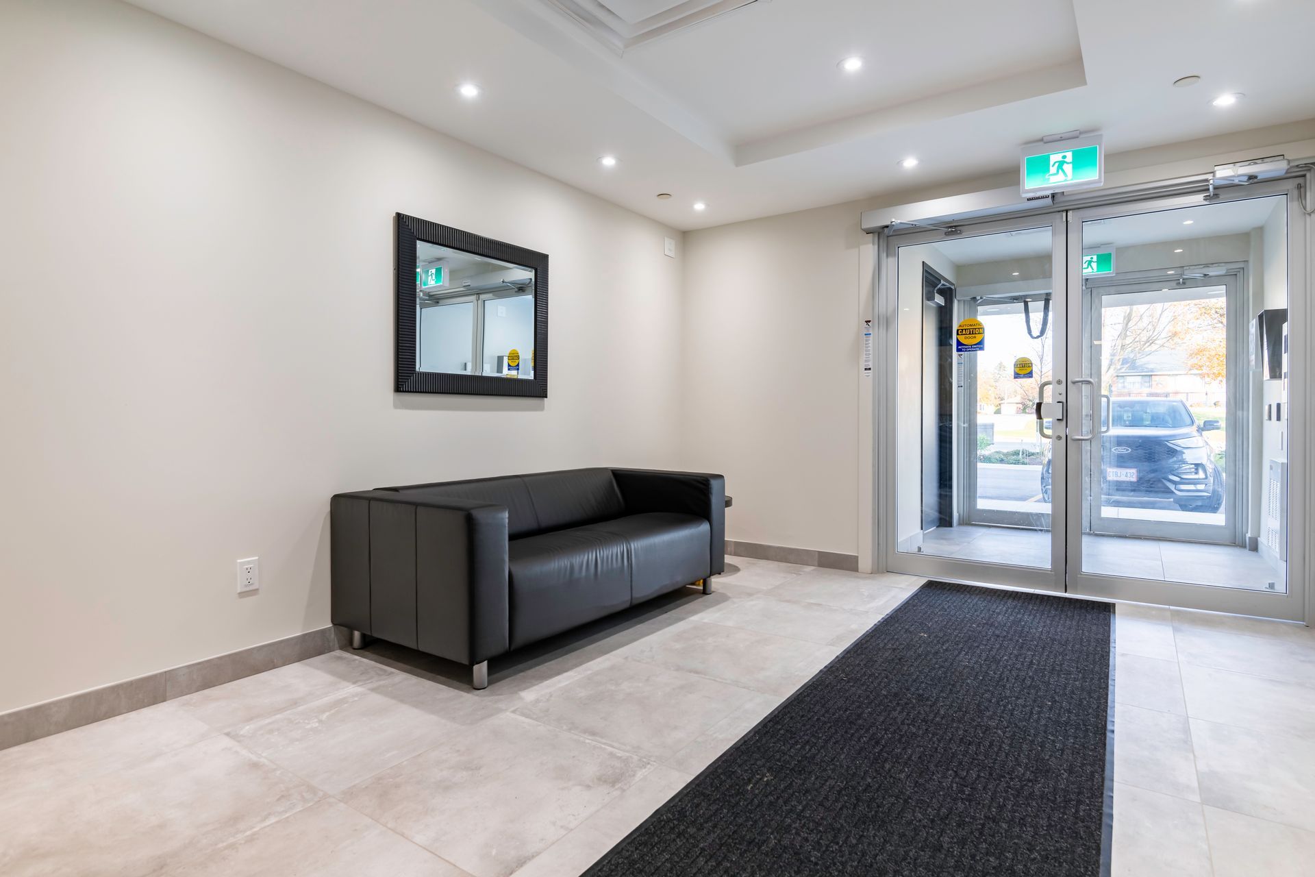 A lobby with a couch and a mirror on the wall.
