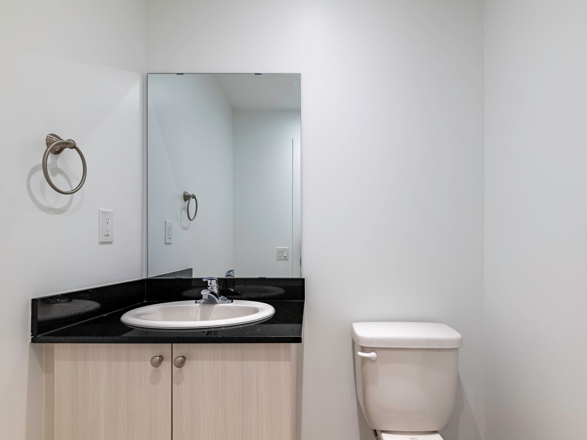 A bathroom with a sink , toilet and mirror.