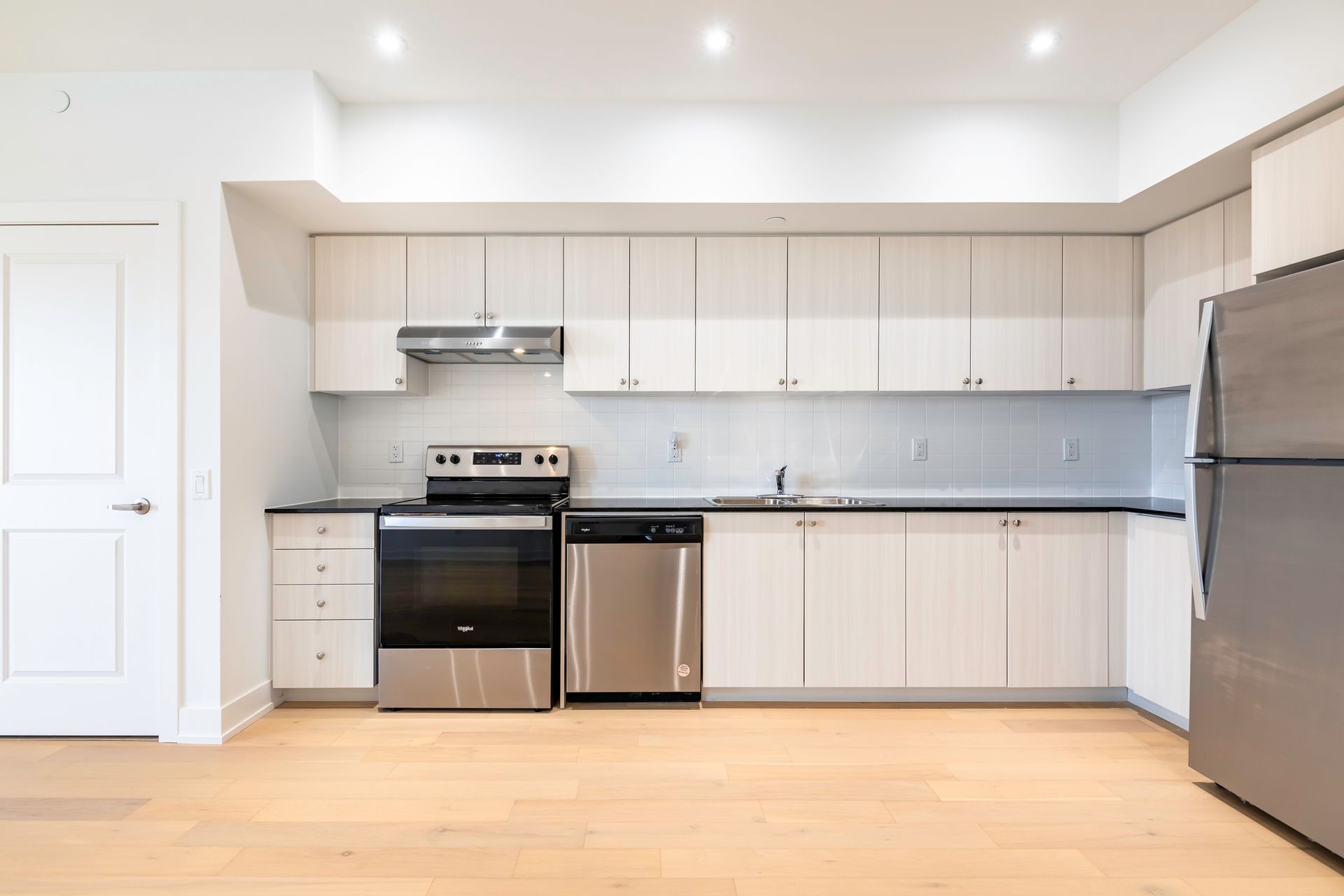 A kitchen with stainless steel appliances and white cabinets