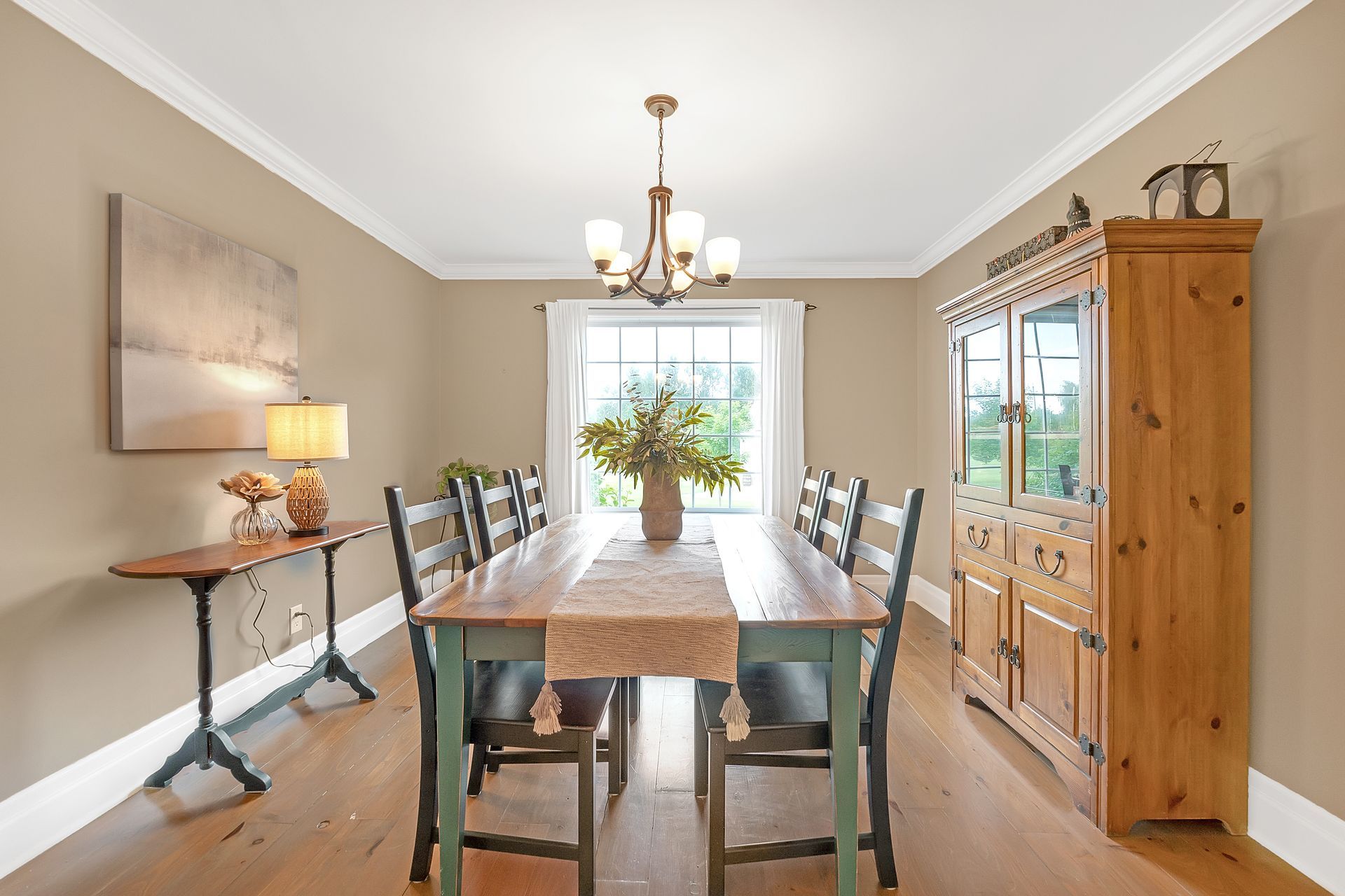 A dining room with a long wooden table and chairs