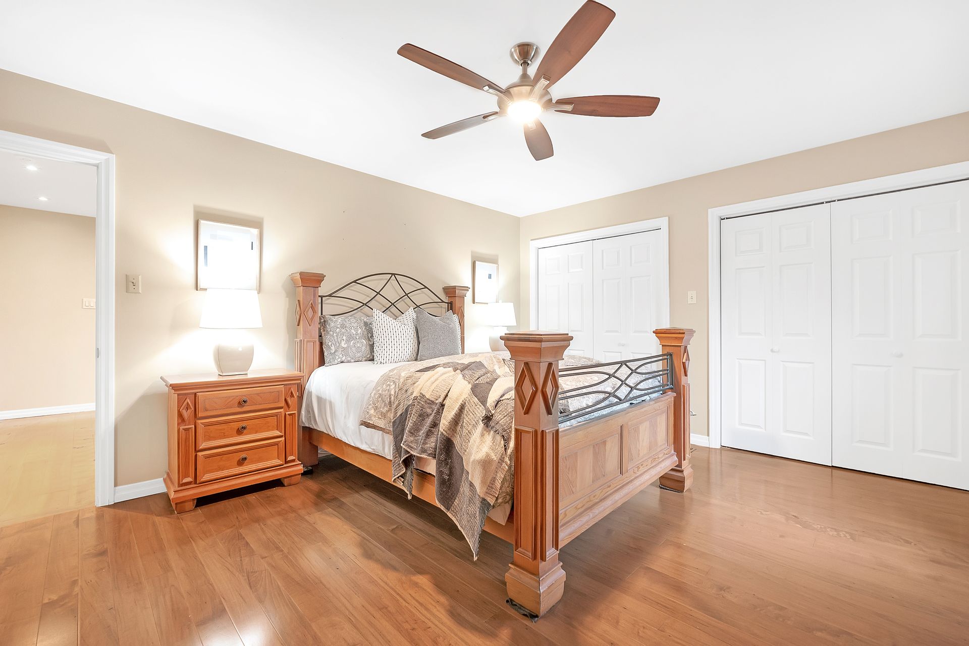 A bedroom with a bed , nightstand , and ceiling fan.