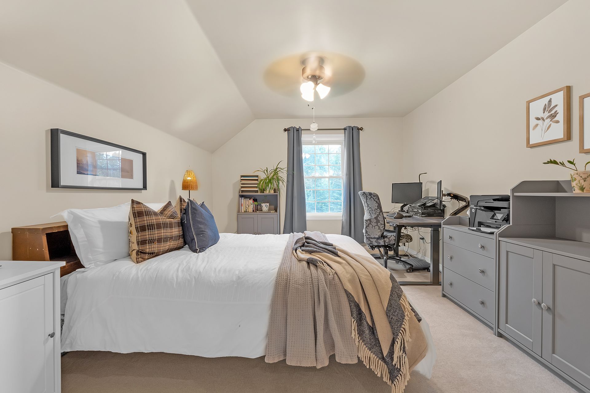 A bedroom with a bed and a desk in it