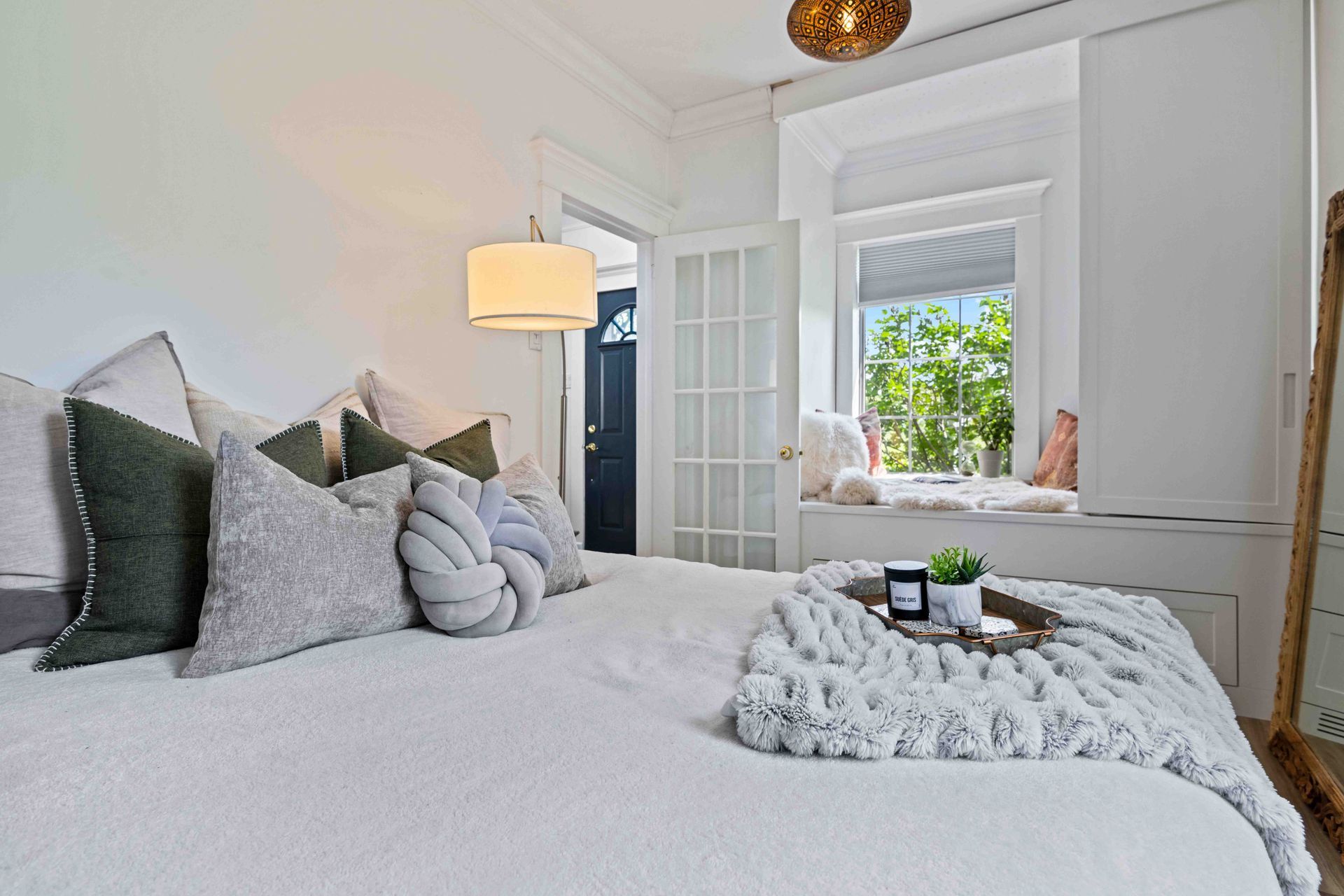 A bedroom with a large bed and a window seat.