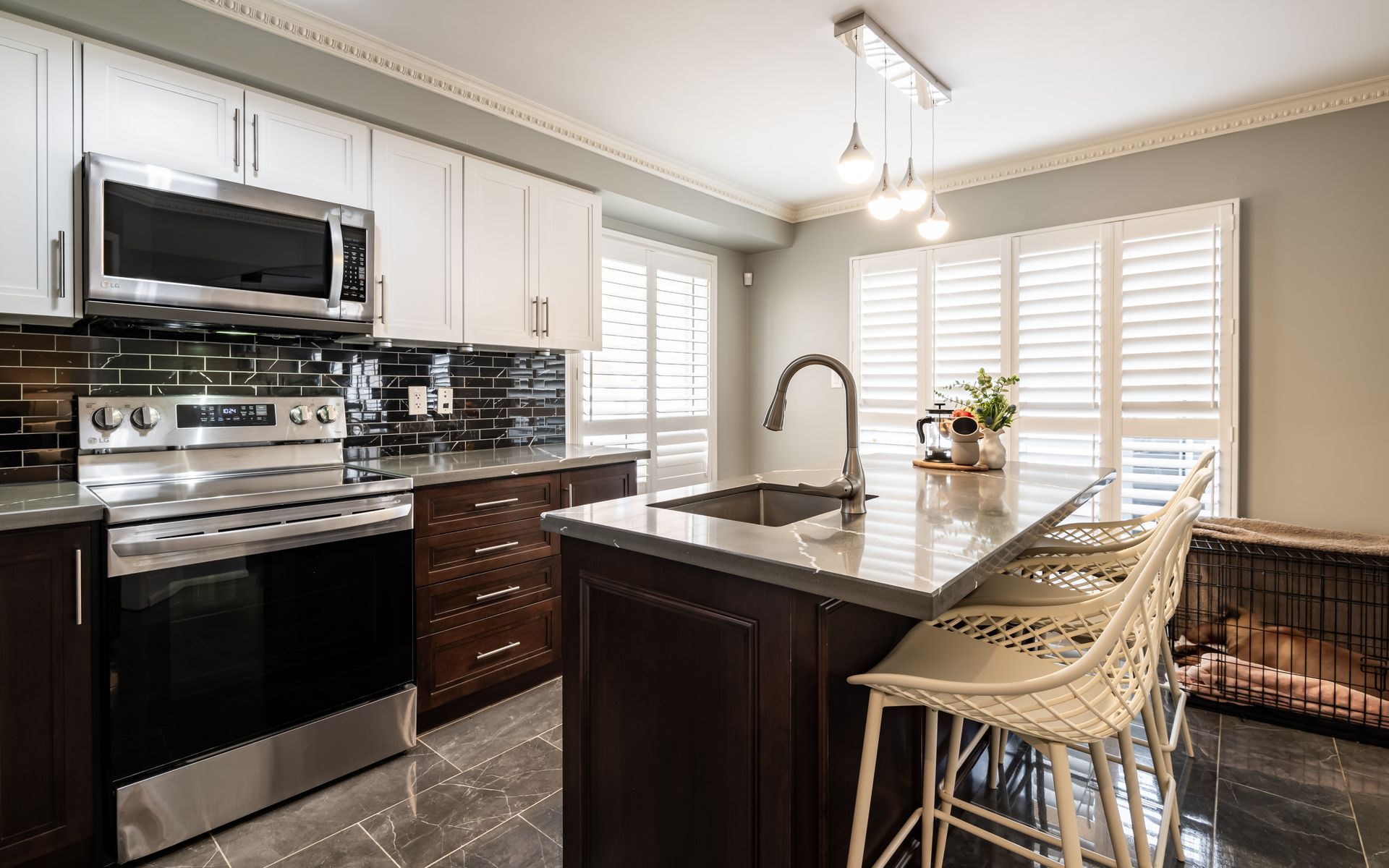A kitchen with stainless steel appliances , granite counter tops , a sink , and a stove.
