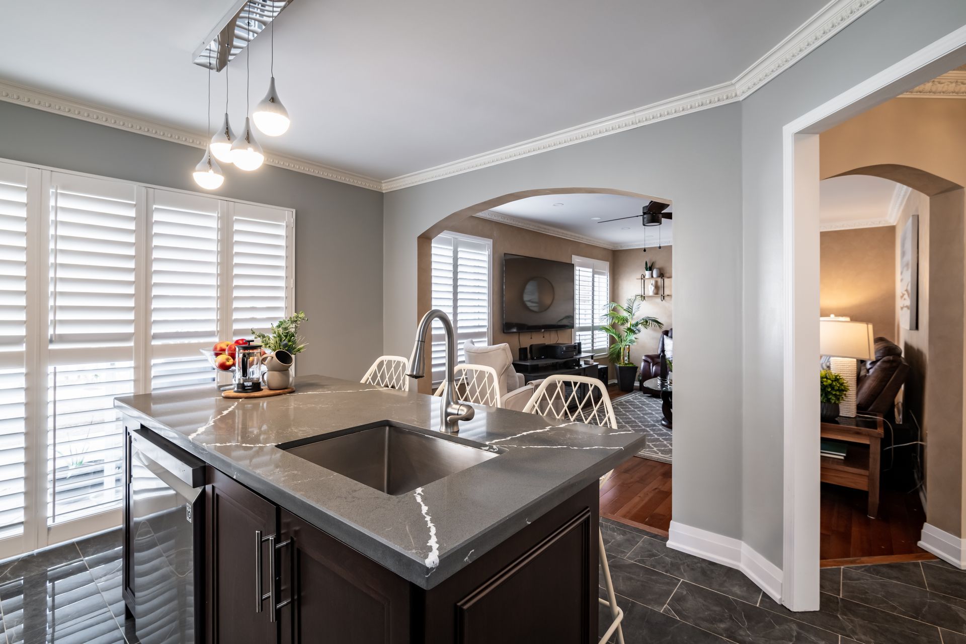 A kitchen with a sink and a large island in the middle of the room.