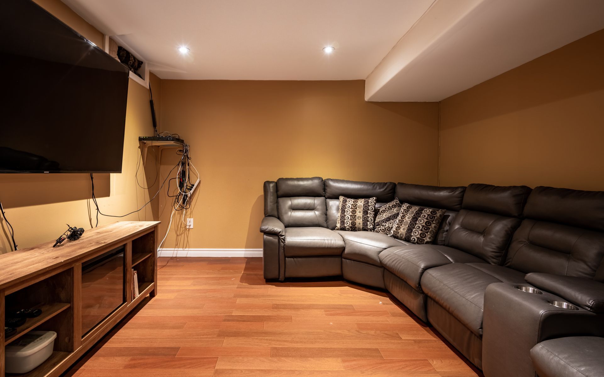 A living room with a large sectional couch and a flat screen tv.