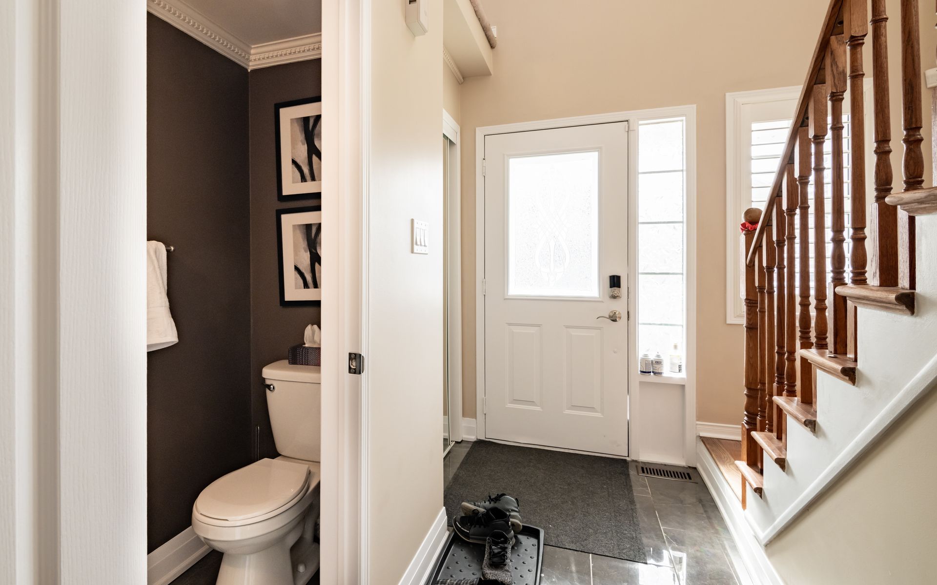 A hallway in a house with a toilet and stairs