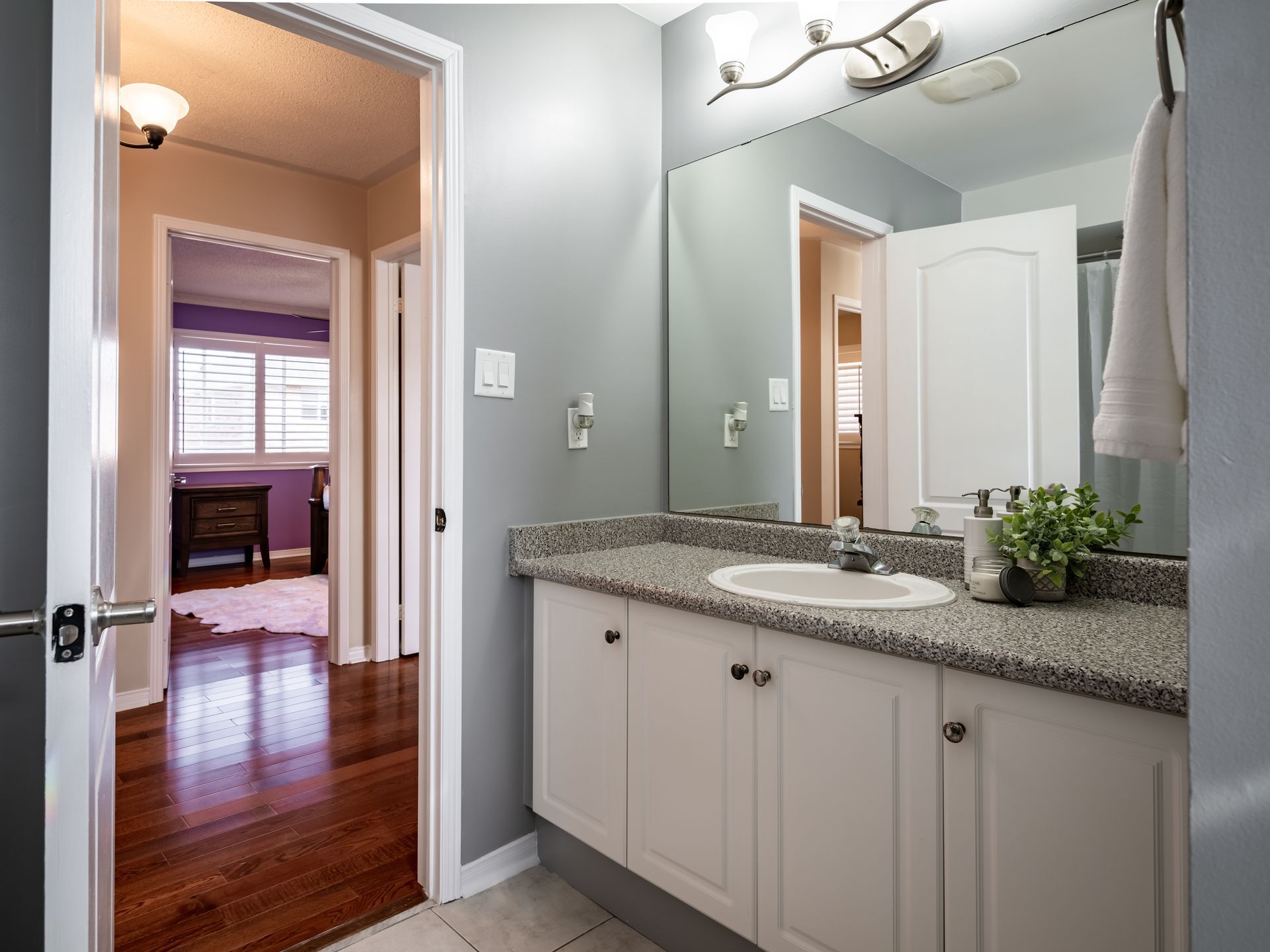 A bathroom with a sink , mirror and cabinets