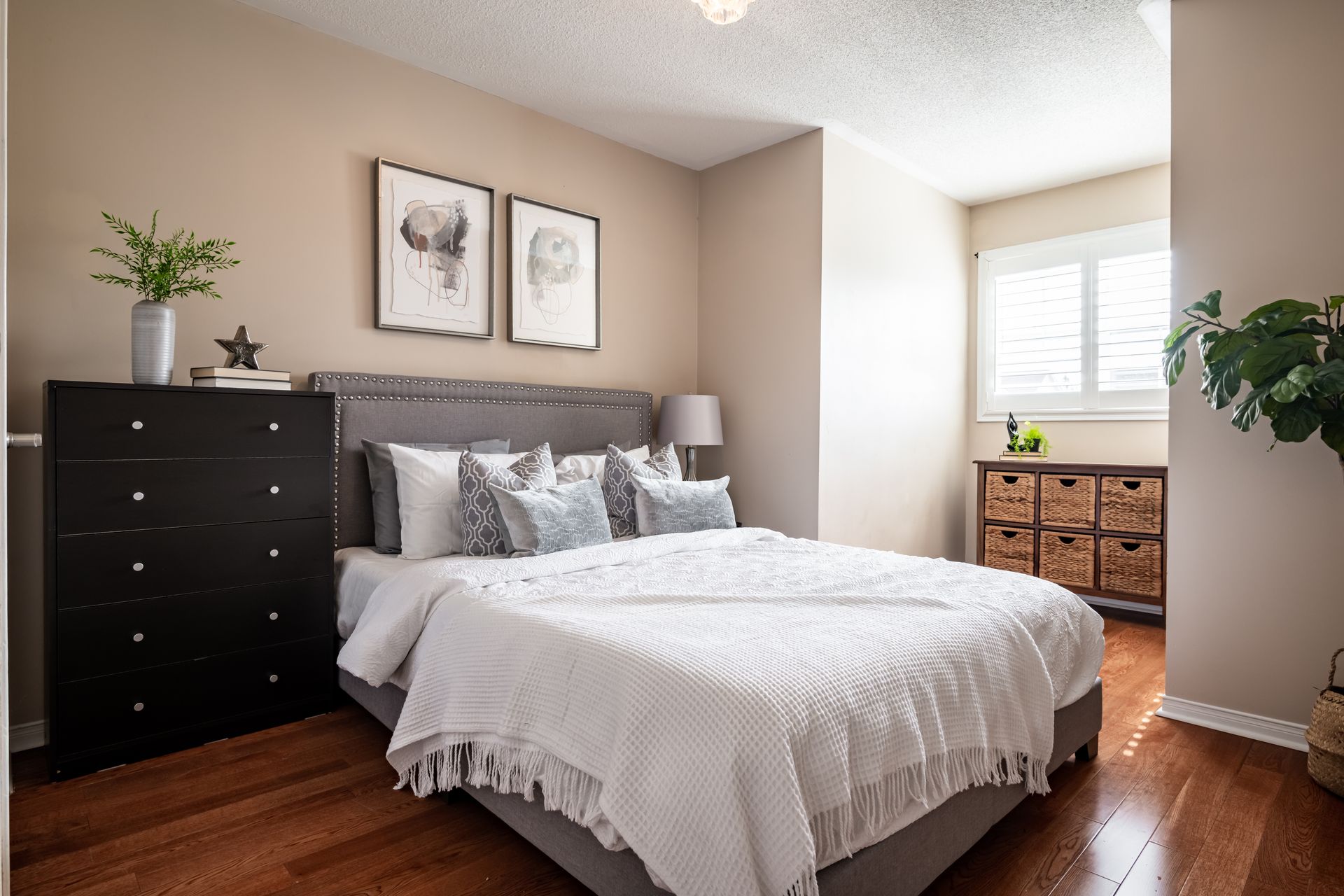 A bedroom with a king size bed and a dresser.