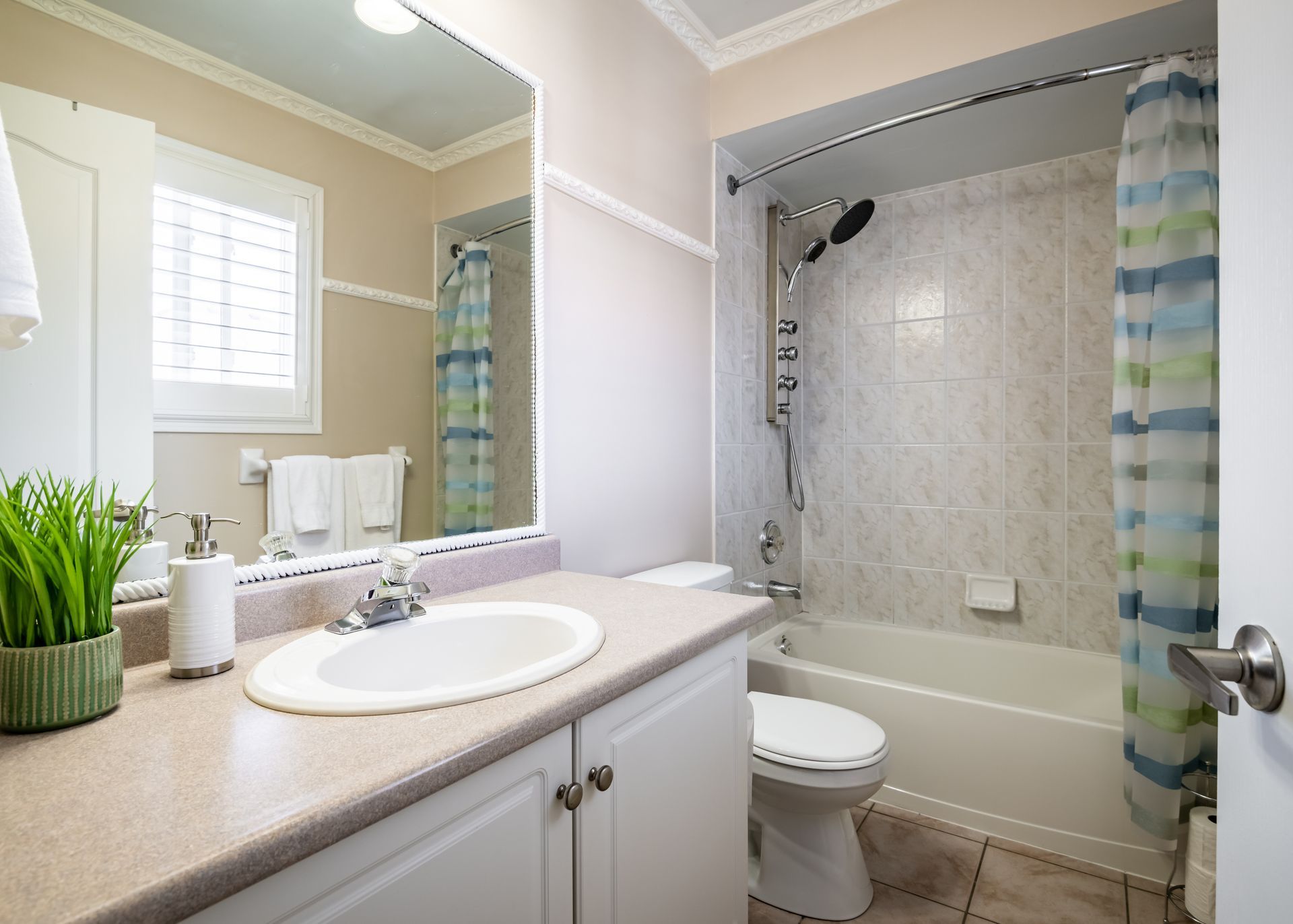 A bathroom with a sink , toilet , tub and mirror.