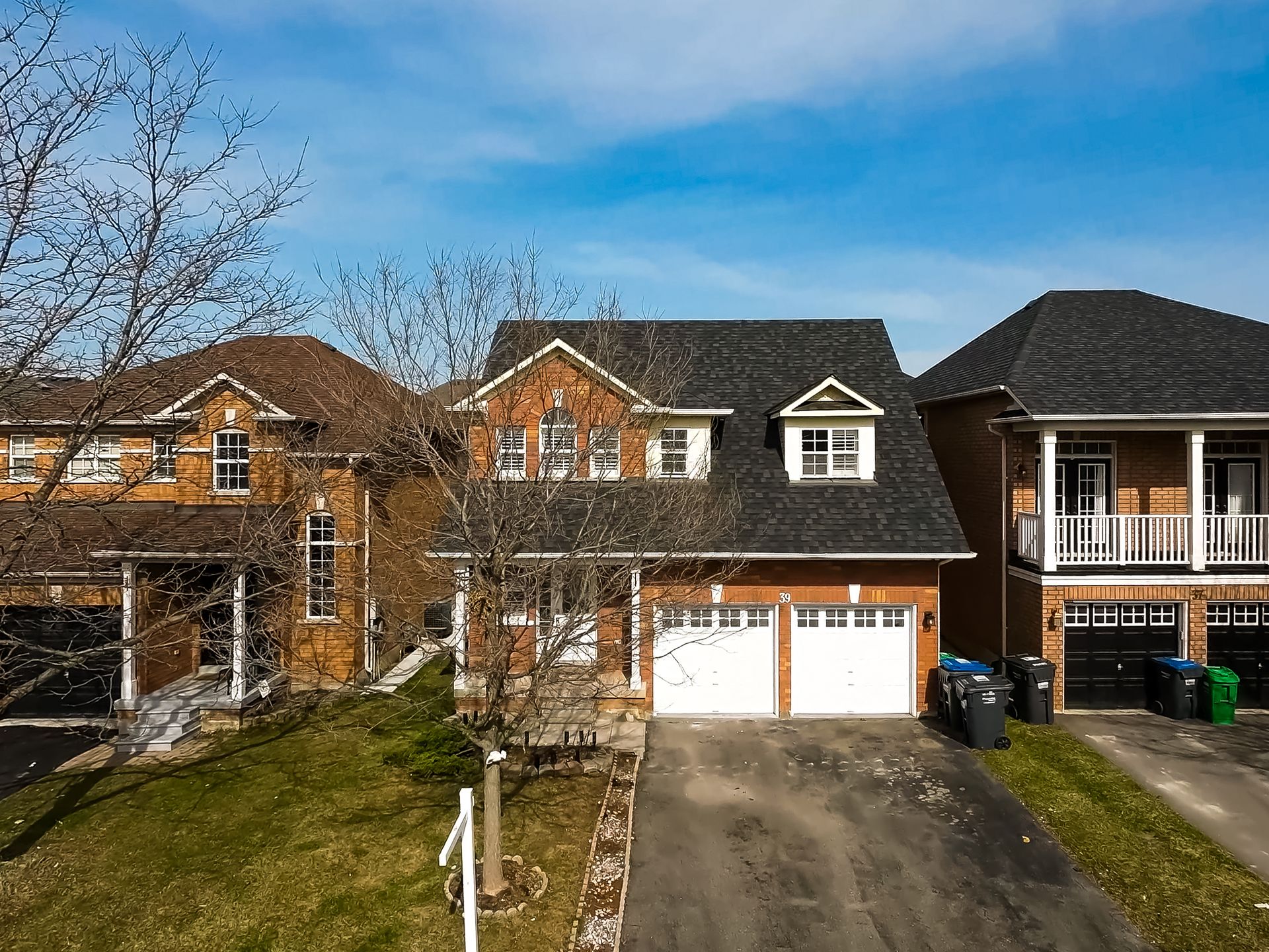 An aerial view of a house with two garages and a driveway.