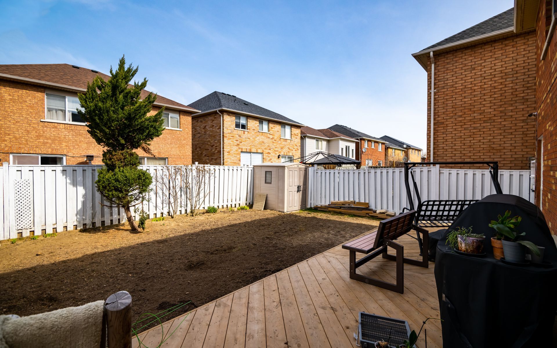 There is a wooden deck in the backyard of a house.