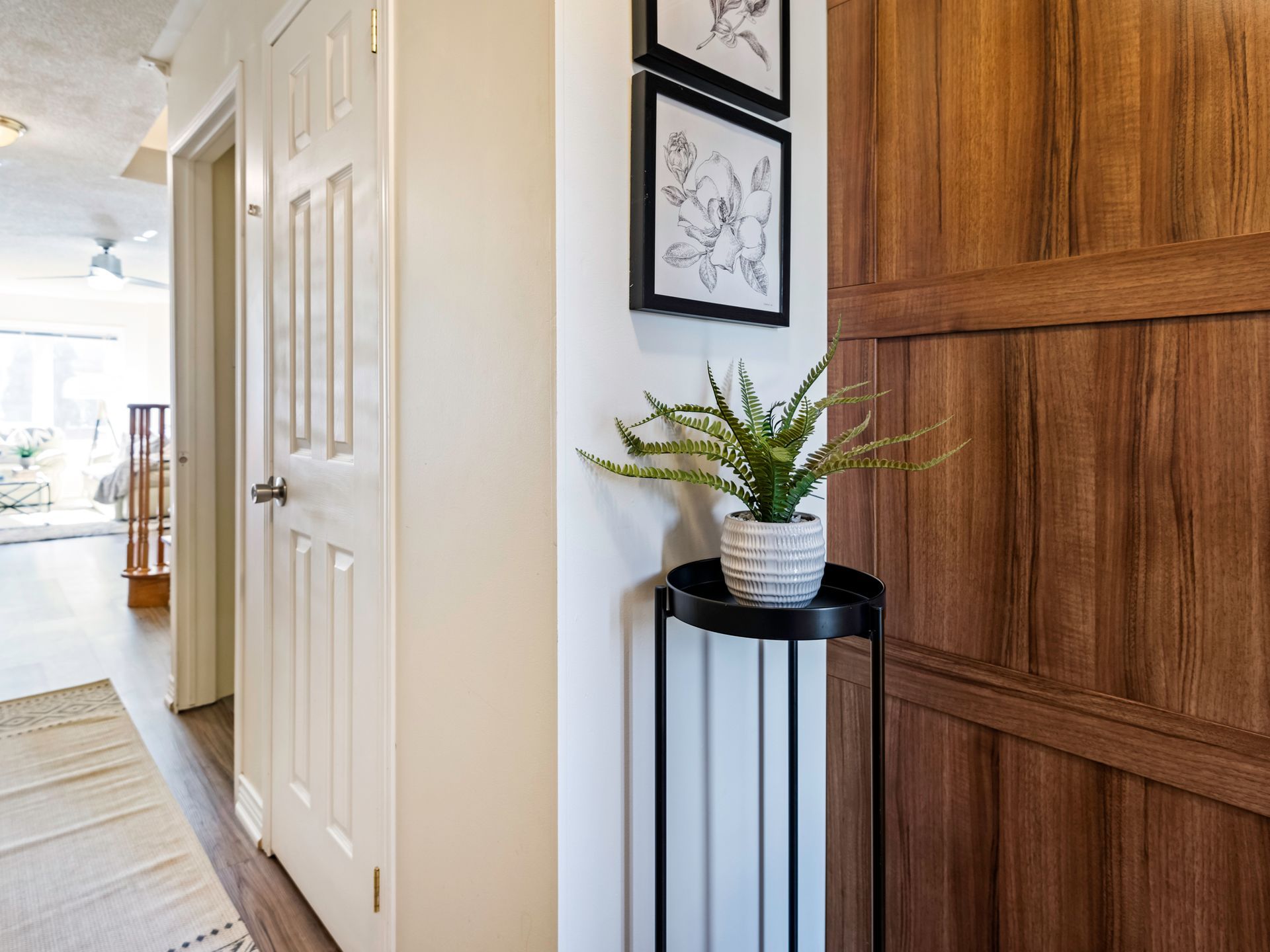 A plant is sitting on a table in a hallway next to a door.